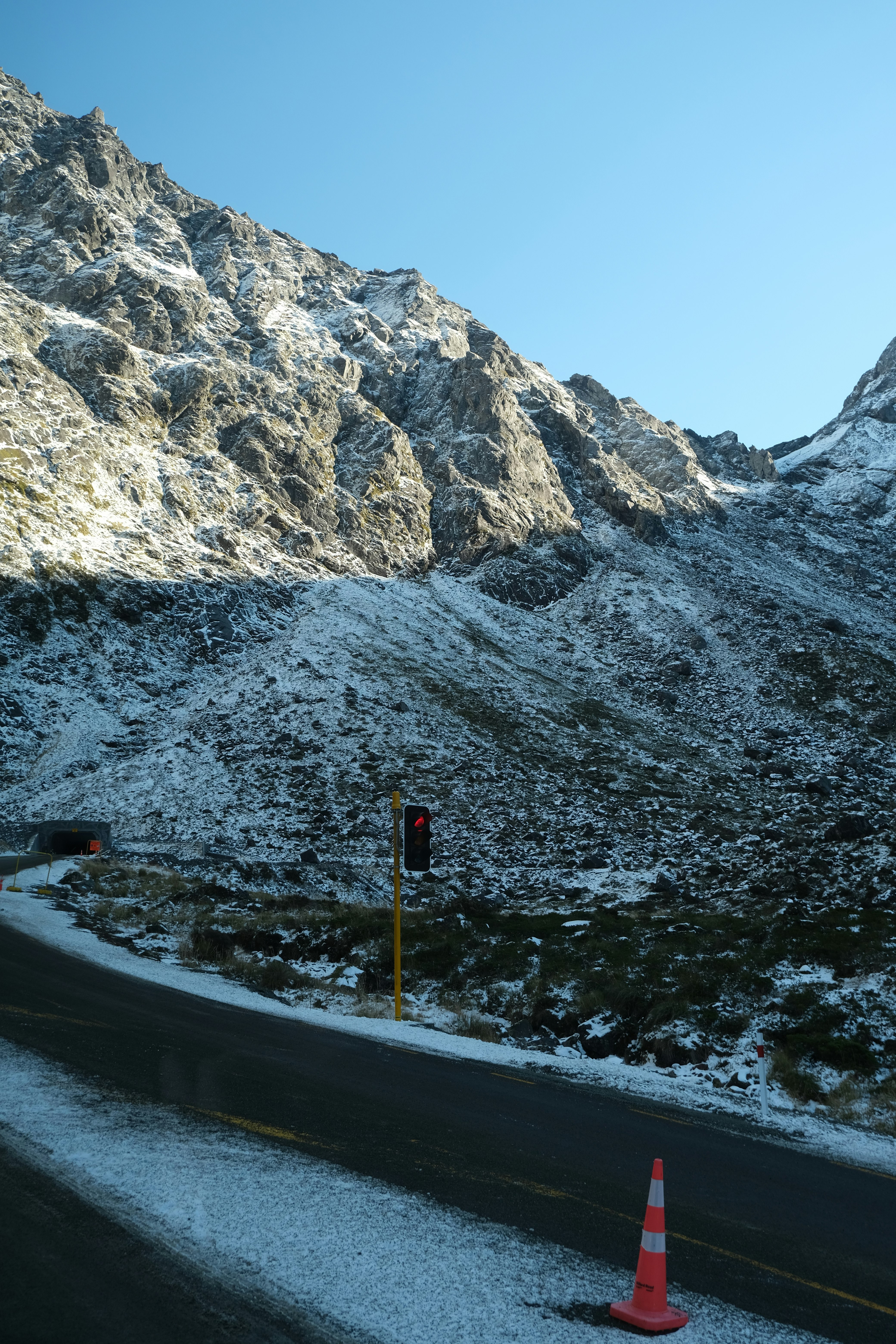 积雪山路，路边锥形路标与防雪屏障