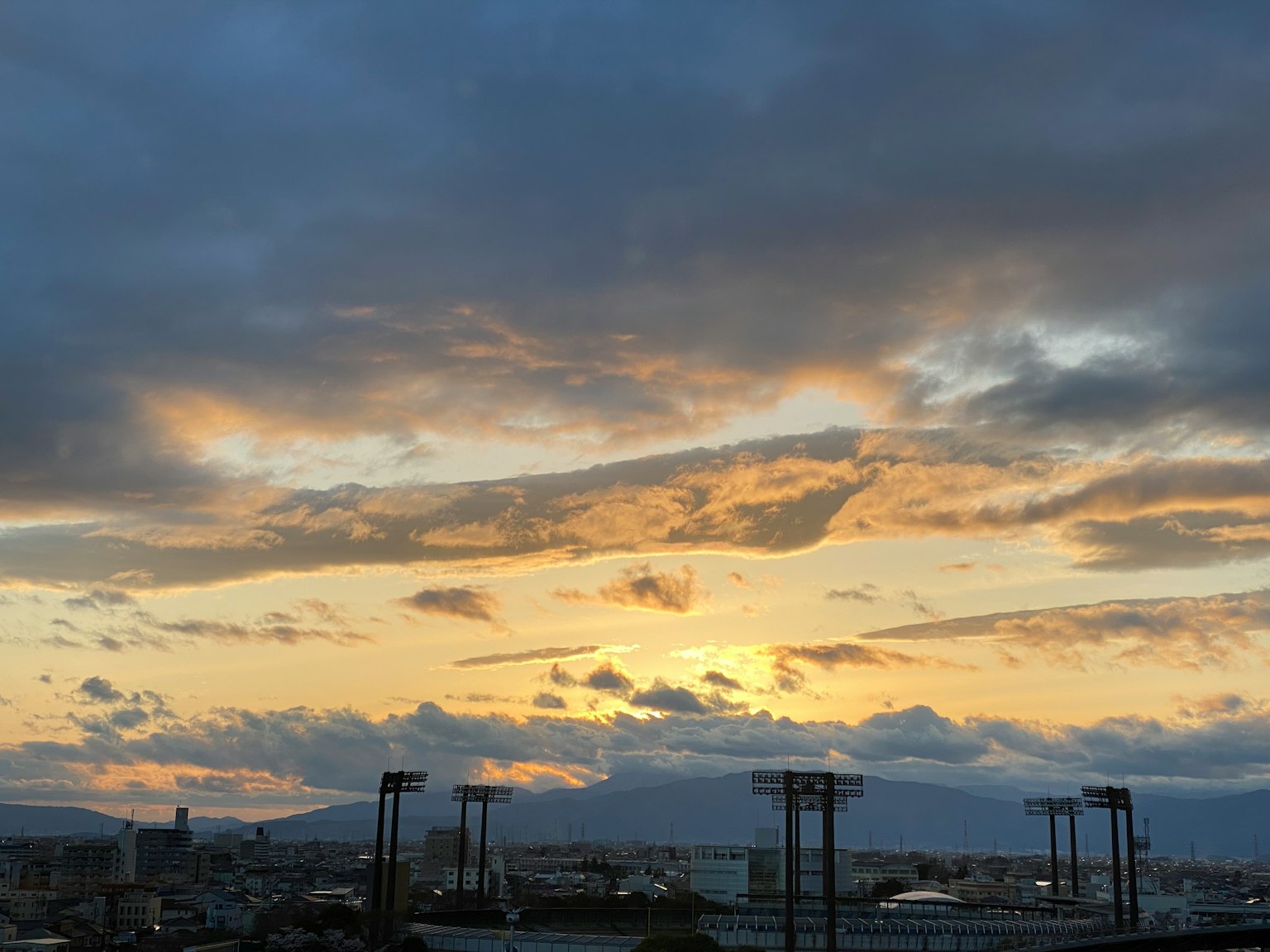 Silhouetten von Bergen und Wolken in einem bunten Sonnenuntergangshimmel