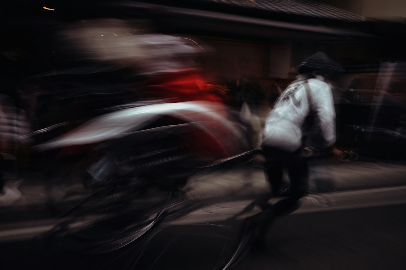 Eine Szene mit einem Radfahrer und einer Person, die mit Bewegungsunschärfe eine Straße entlang eilen