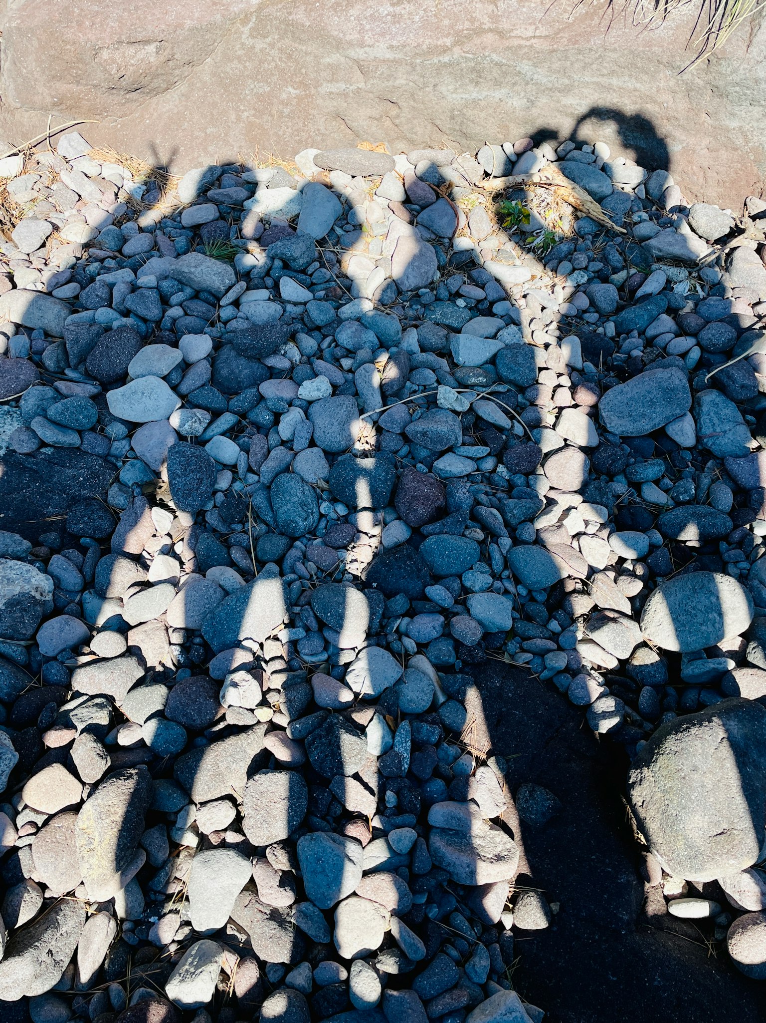 Shadows of people standing on rocks creating playful shapes