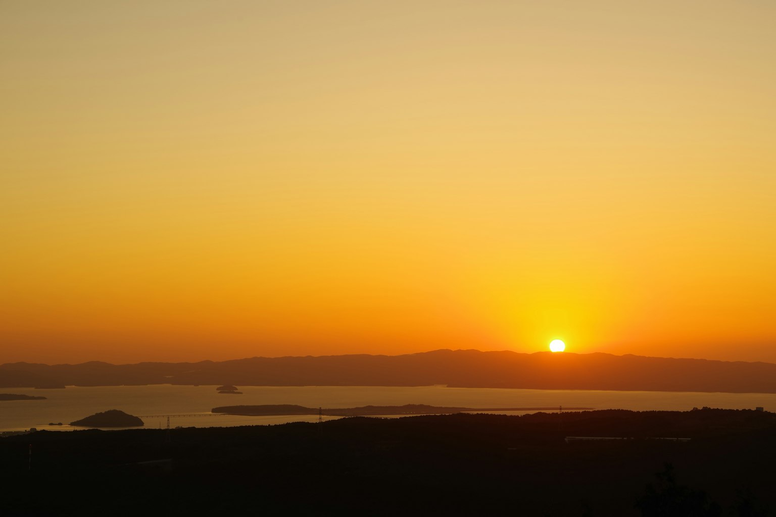 Schöner Sonnenuntergang über dem Ozean mit Silhouetten von fernen Inseln