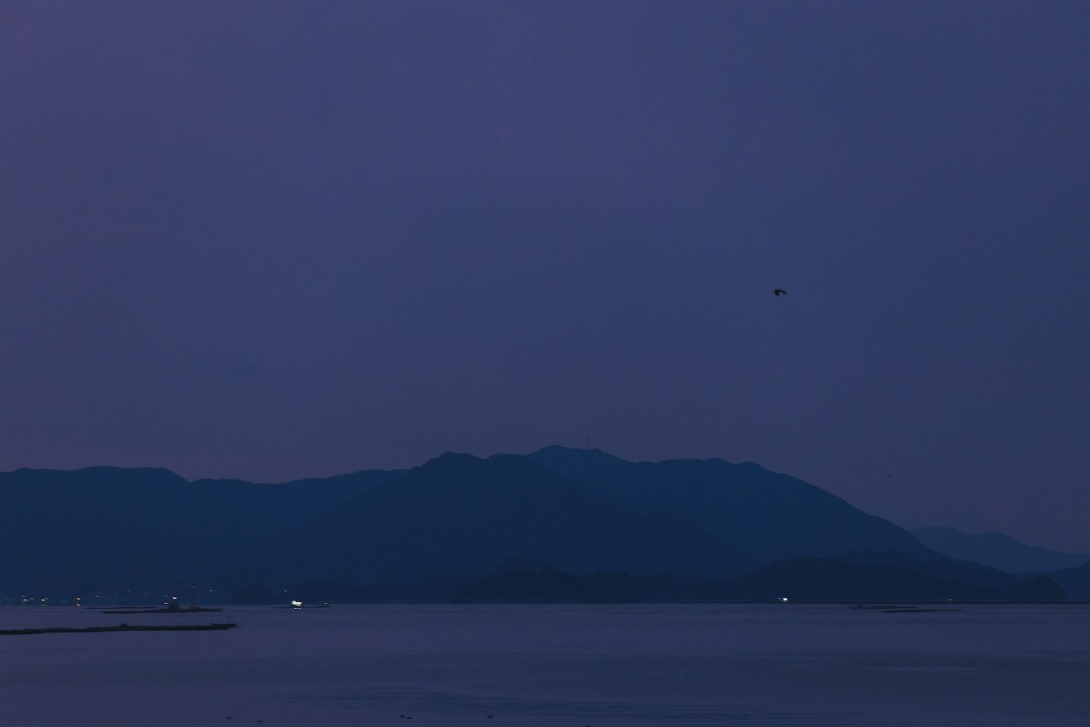 Vue calme d'un lac nocturne avec des montagnes en arrière-plan