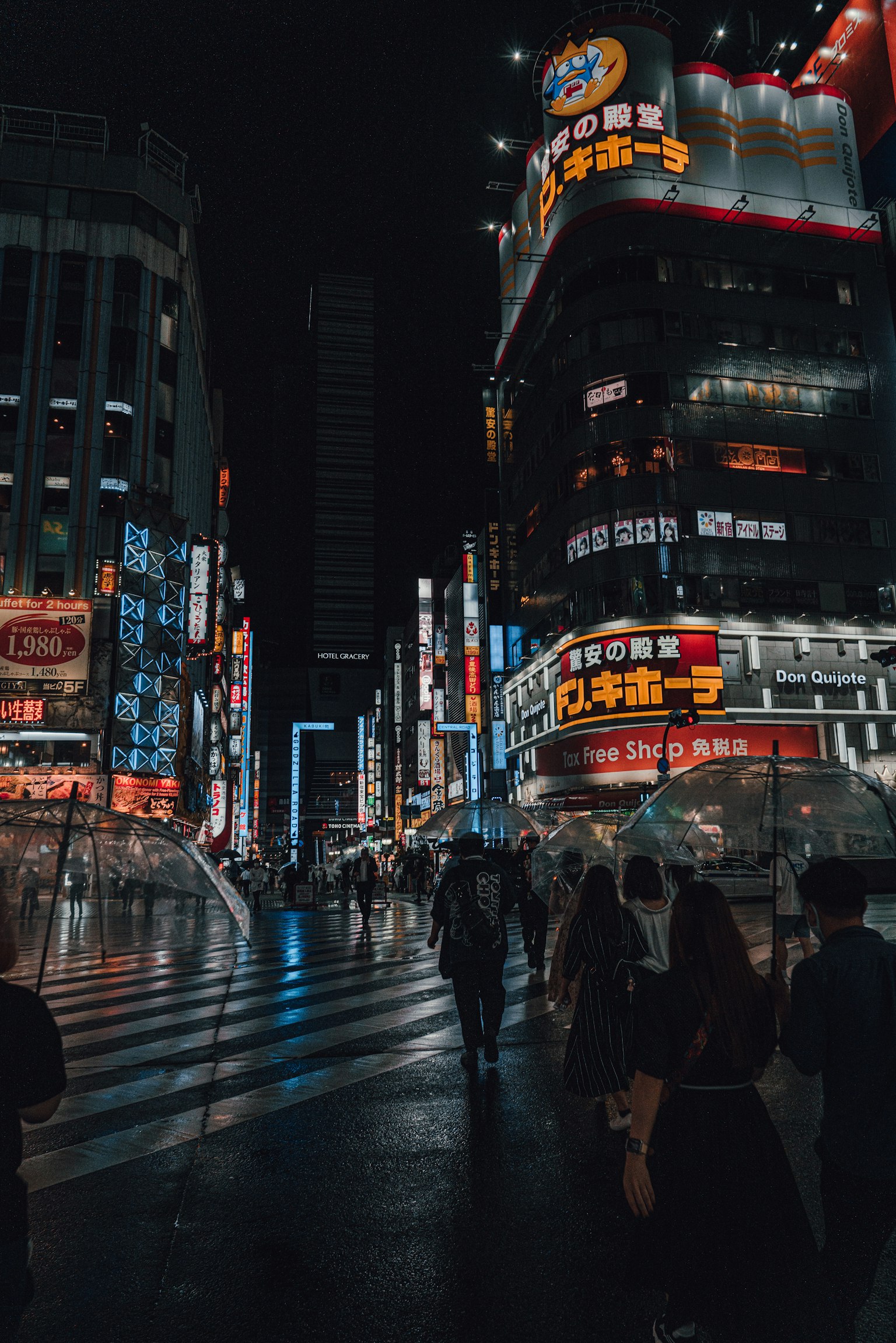 Esquina de la ciudad por la noche con personas y brillantes letreros de neón