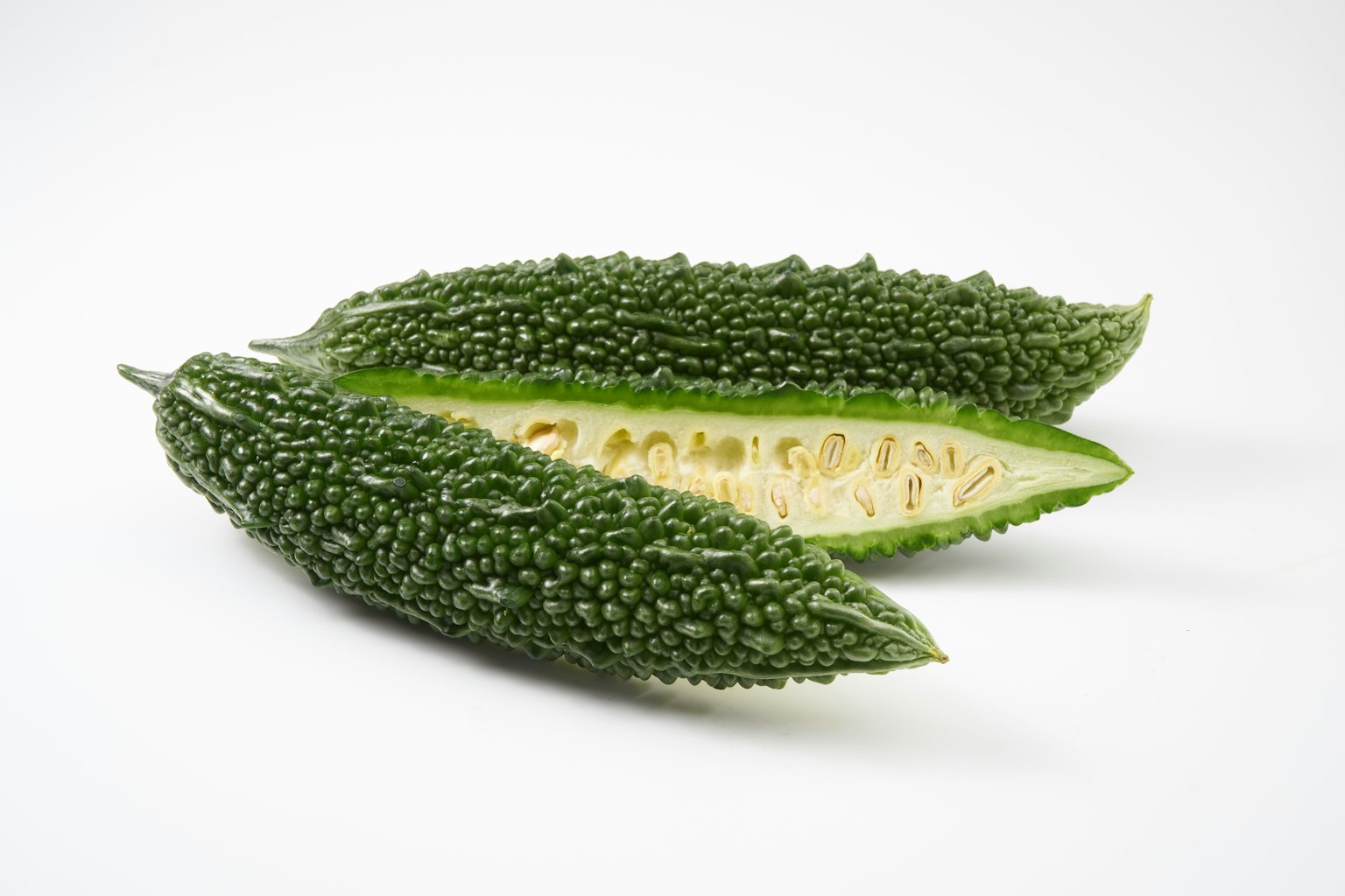 흰색 배경에 있는 두 개의 쓴 멜론