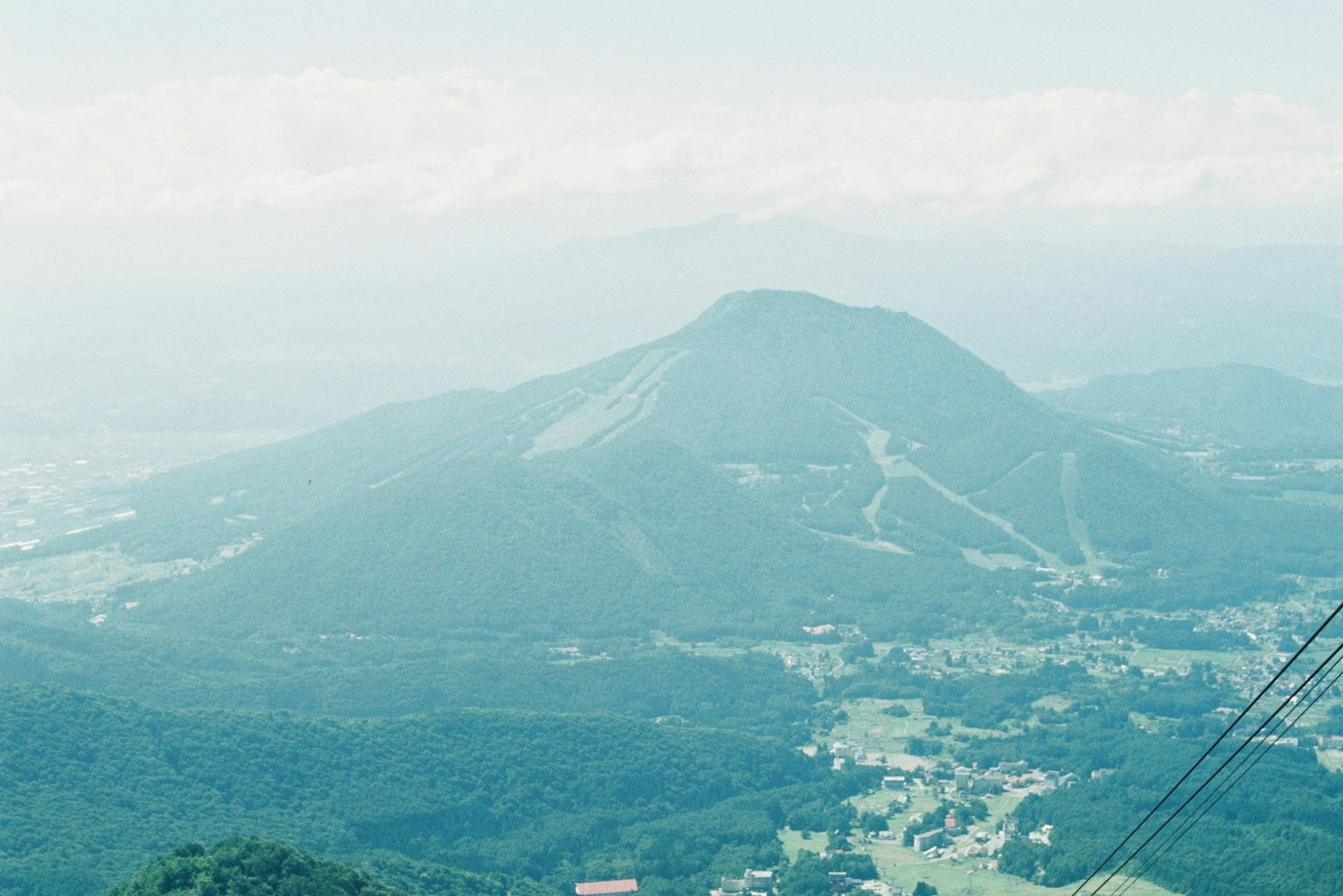 A scenic view of blue mountains and valleys with distant snow-capped peaks