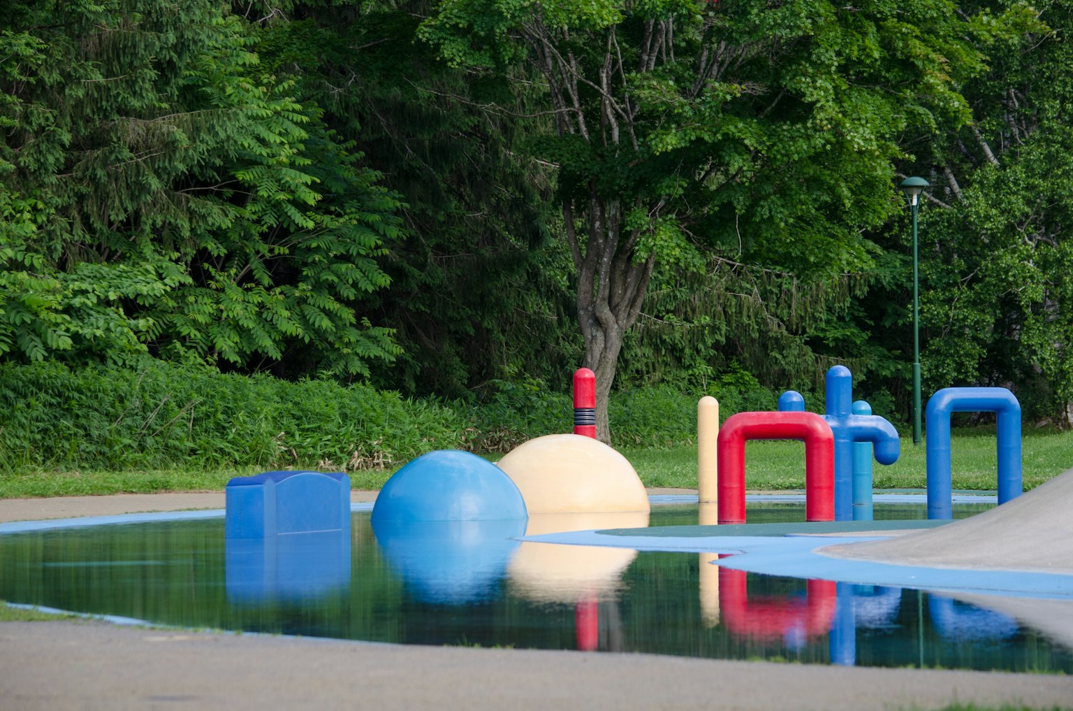 Strutture di gioco colorate in un'area giochi acquatica con superficie d'acqua riflettente