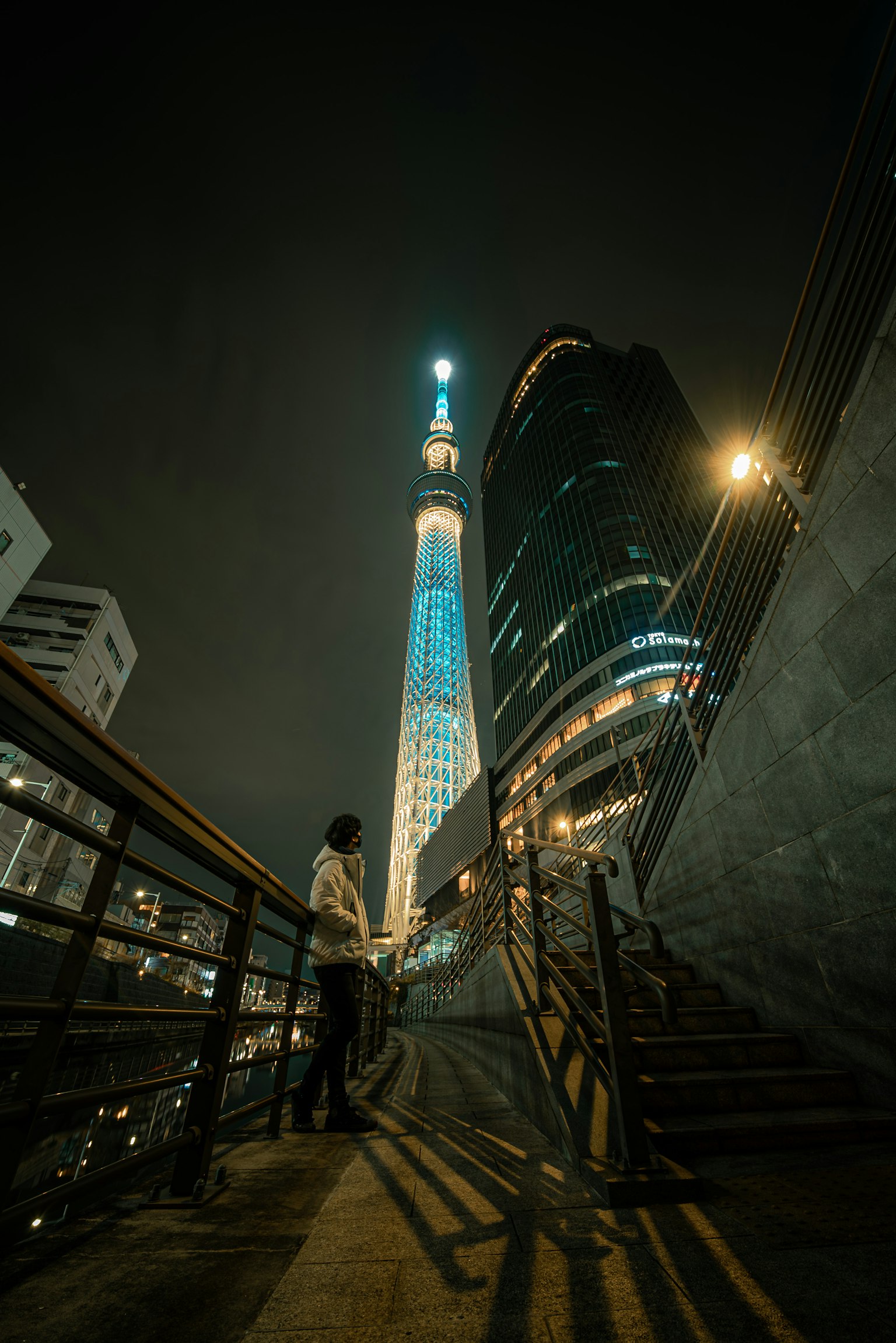 Tokyo Skytree illuminé la nuit avec une personne sur les escaliers