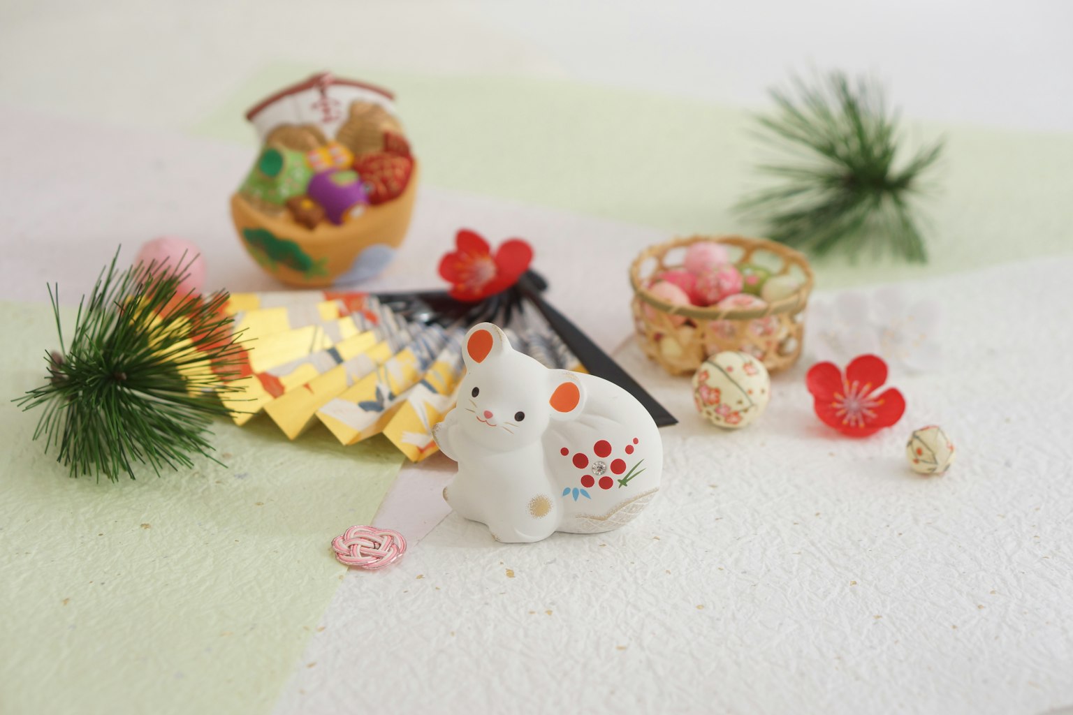 Figurina di topo bianco circondata da decorazioni colorate per il Capodanno
