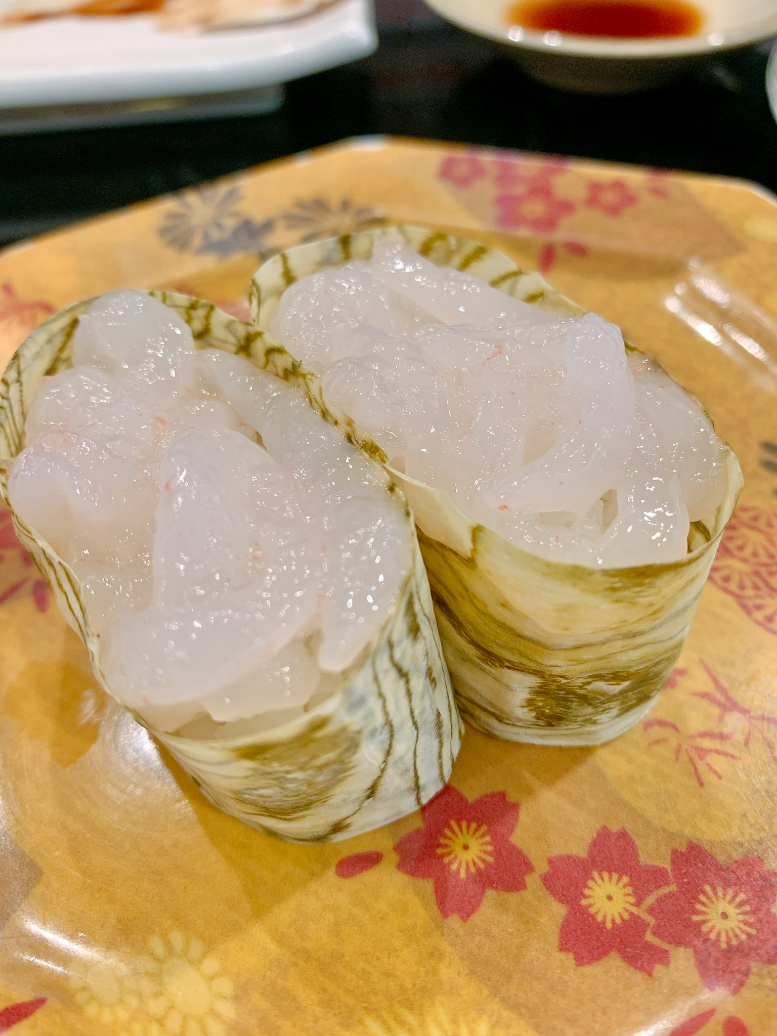 Deux morceaux de sushi blanc servis dans des feuilles de bambou