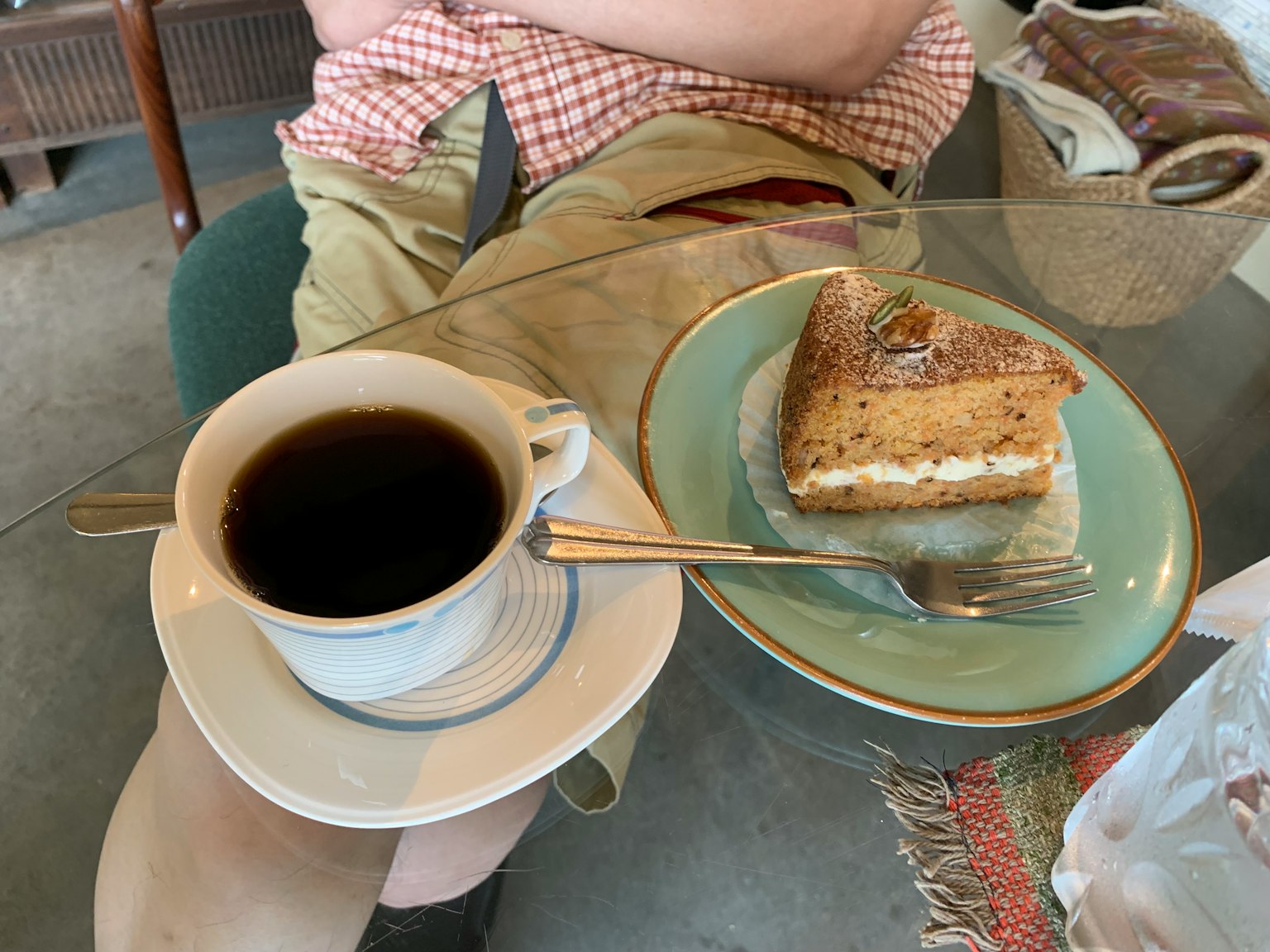 กาแฟหนึ่งถ้วยและเค้กหนึ่งชิ้นบนจาน