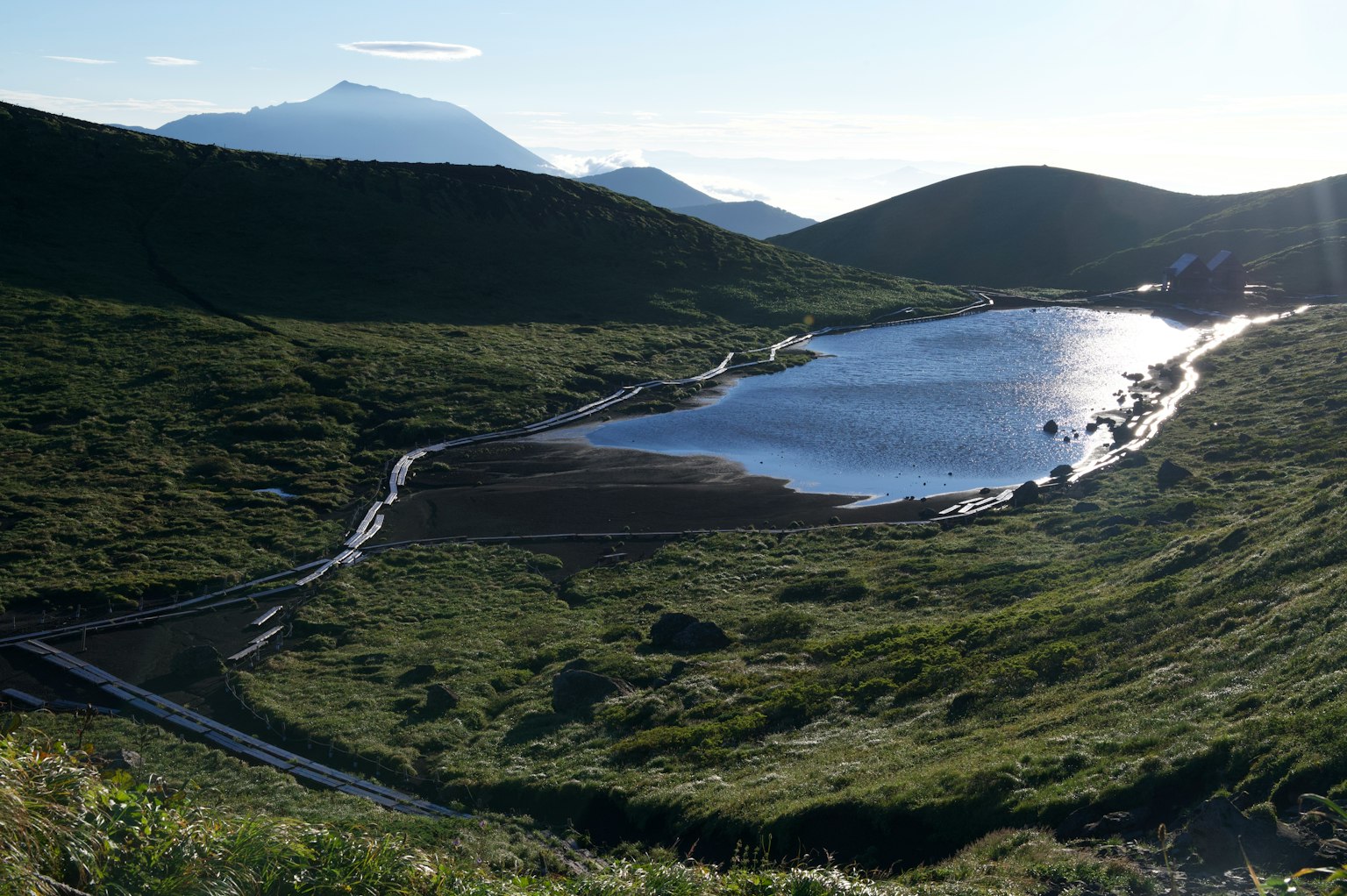 Malersicher Blick auf einen ruhigen See, umgeben von grünen Hügeln