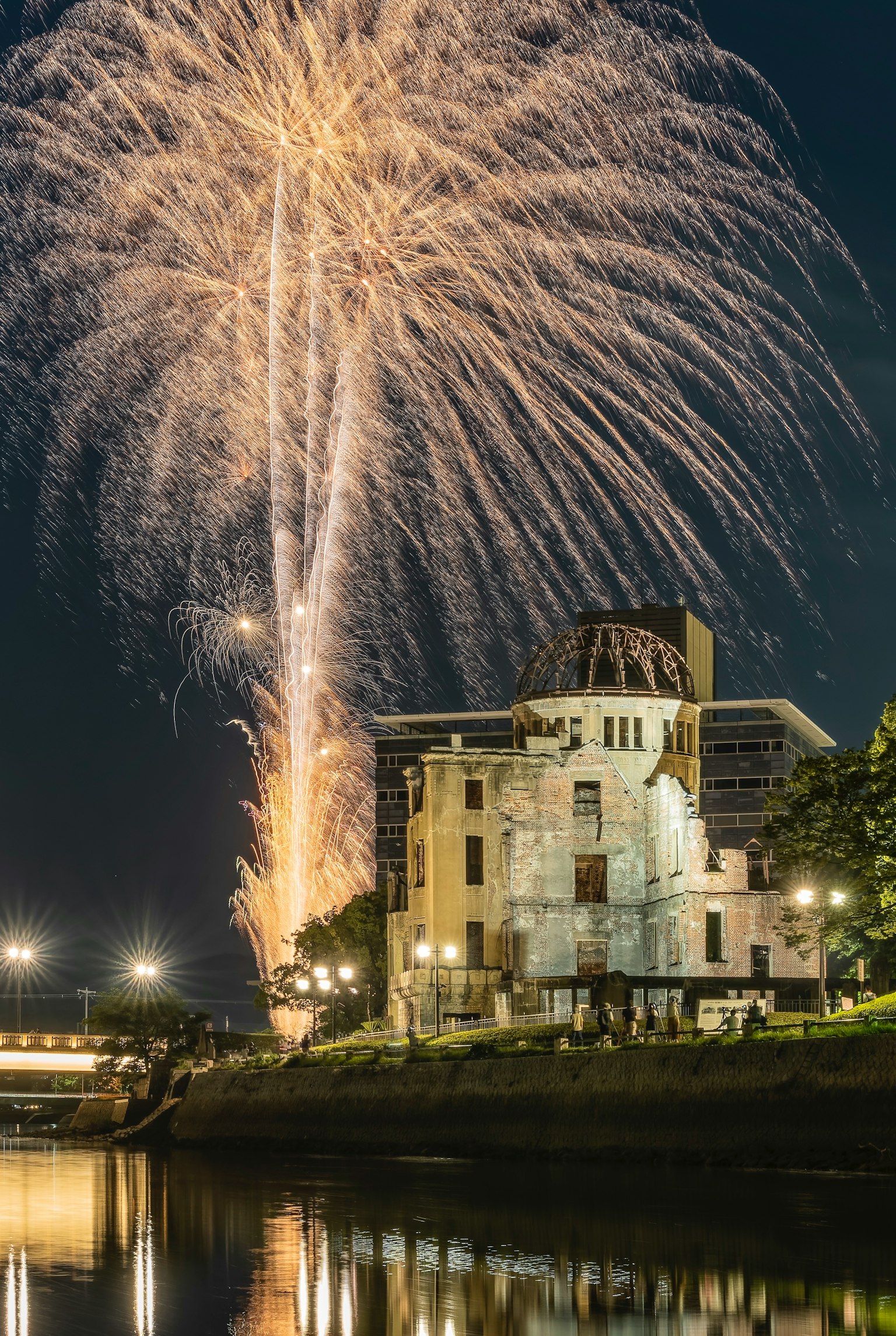 Night view of Hiroshima's Atomic Bomb Dome with fireworks in the background