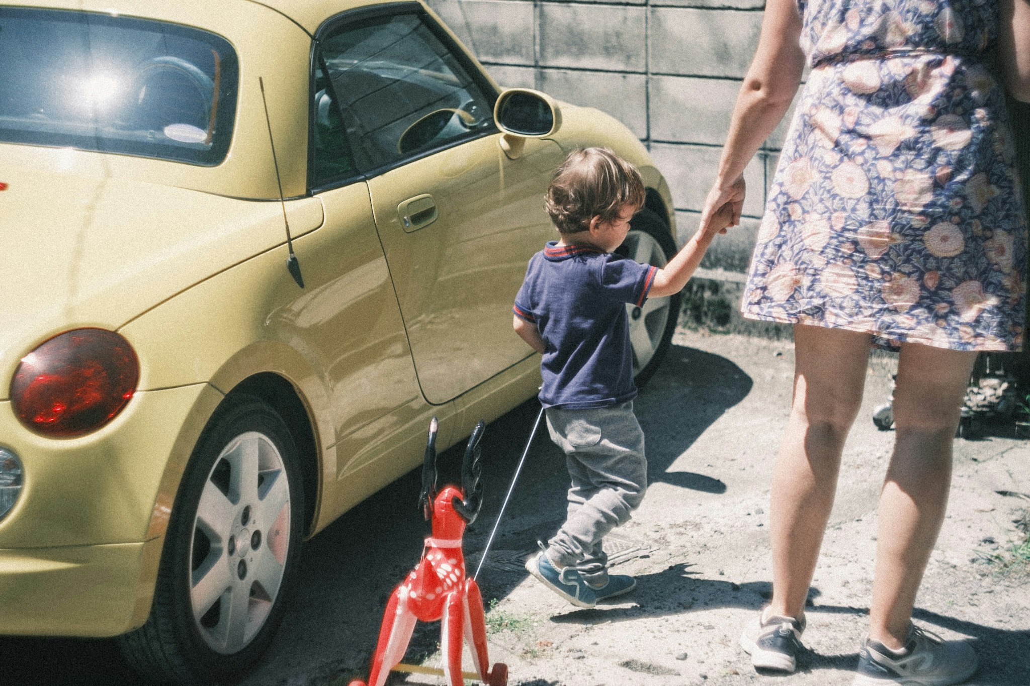 bambino e adulti in piedi accanto a un’auto in strada