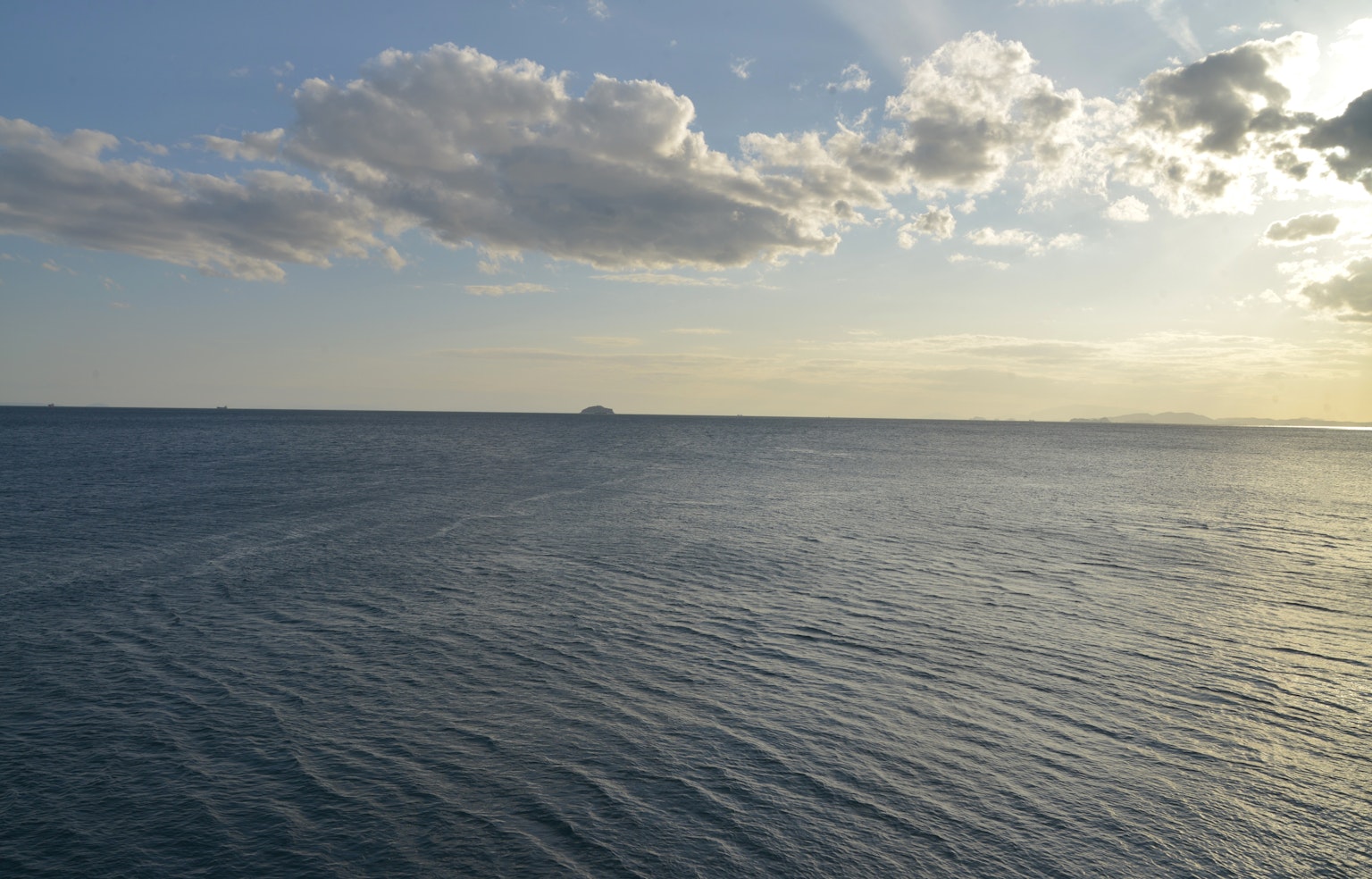 Mare calmo con cielo al tramonto e un'isola lontana