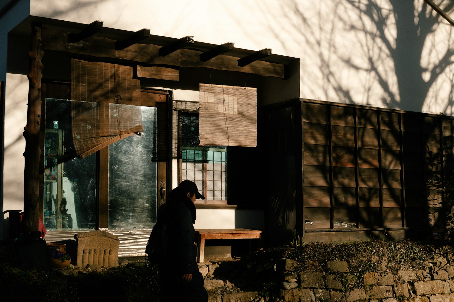 Fachada de una casa de madera con sombras reflejadas en las ventanas