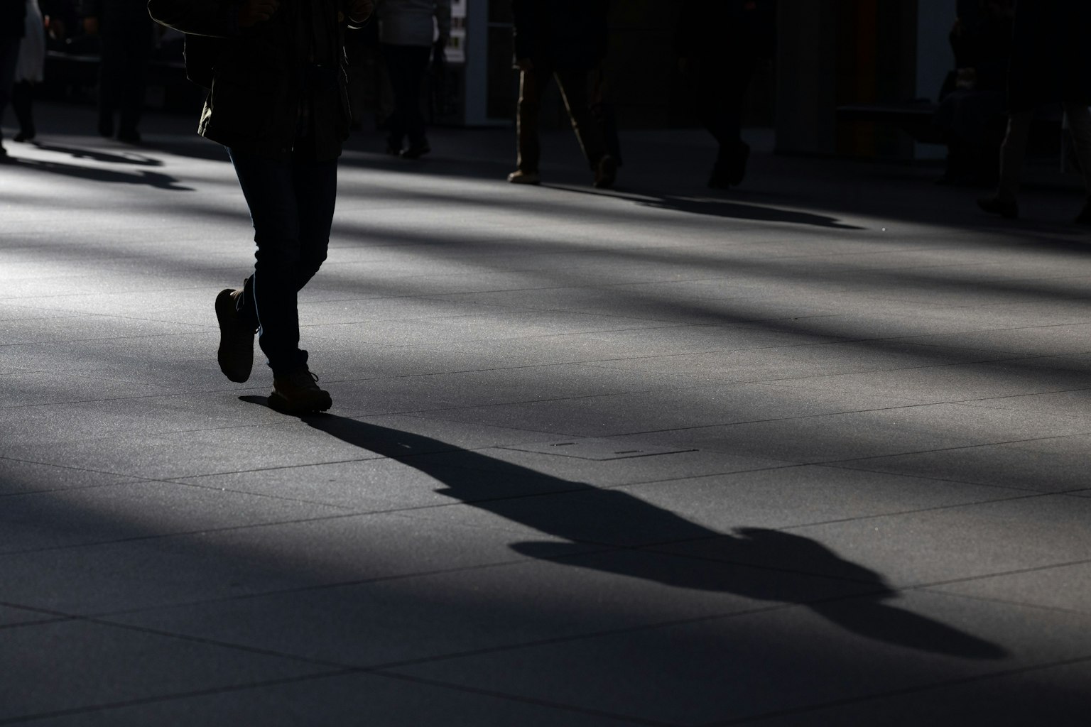 Silueta de una persona caminando sobre el suelo con sombras