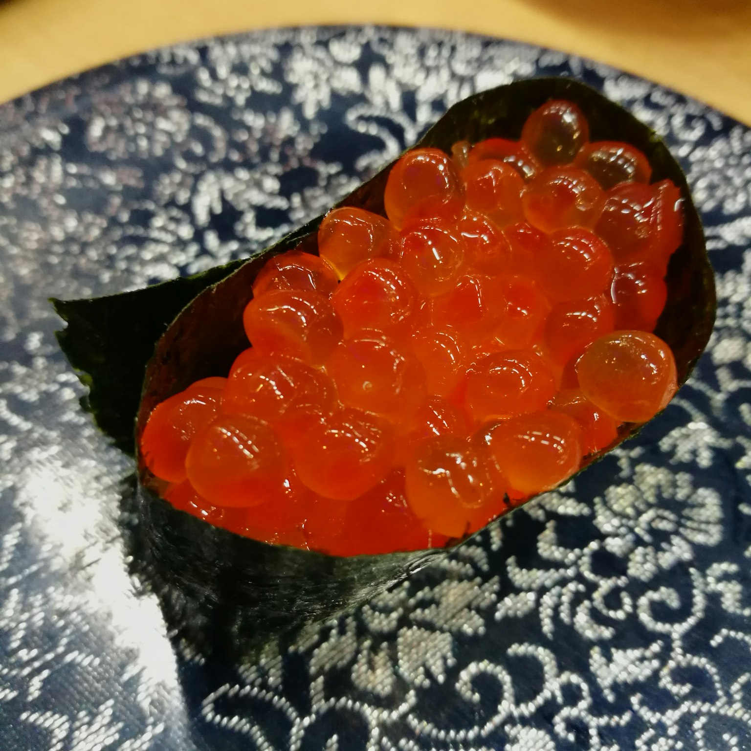 ซูชิที่มีอิคุระสีส้มสดใสห่อด้วยโนริสีดำ