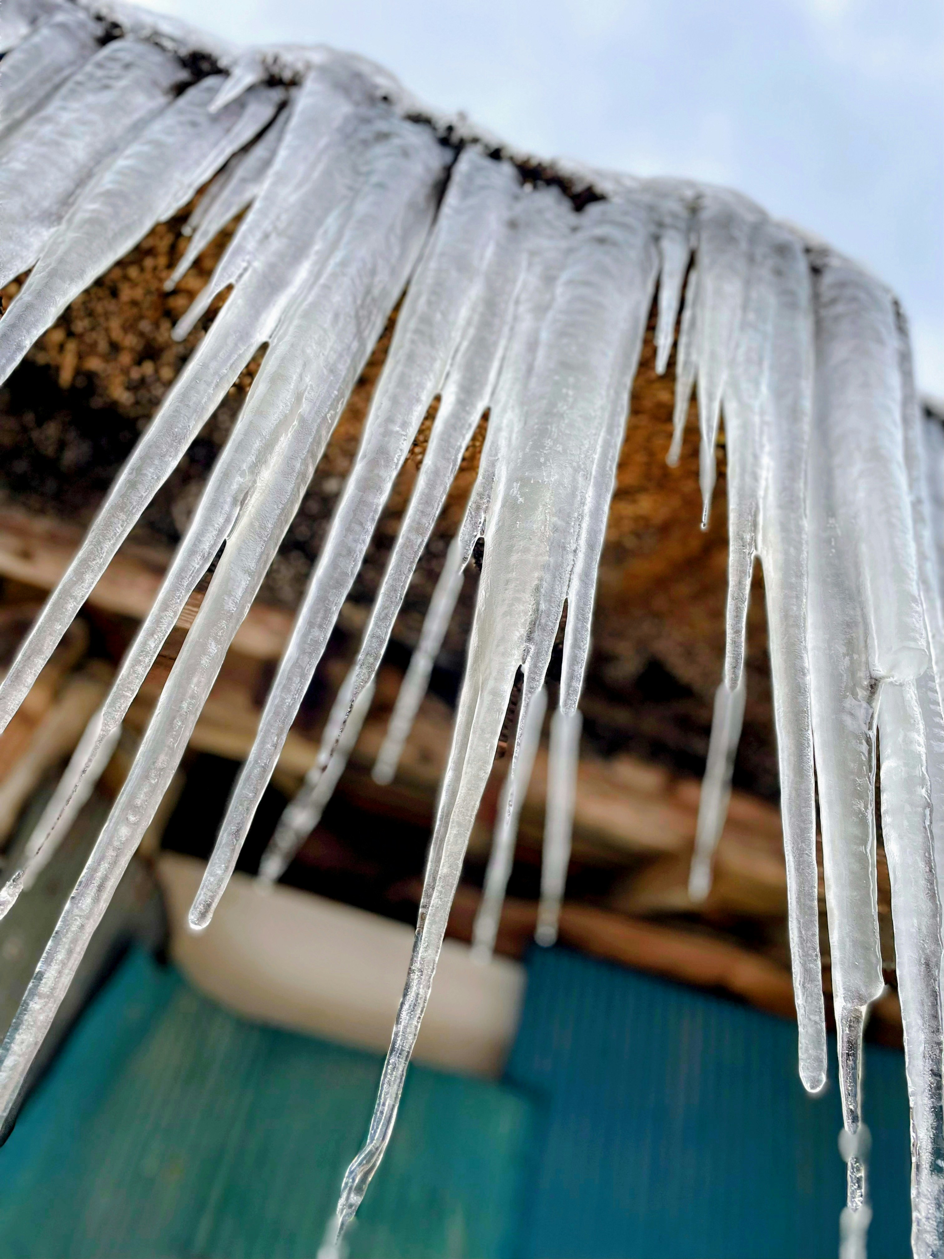 icicle-like transparent icicles hanging from a roof eave