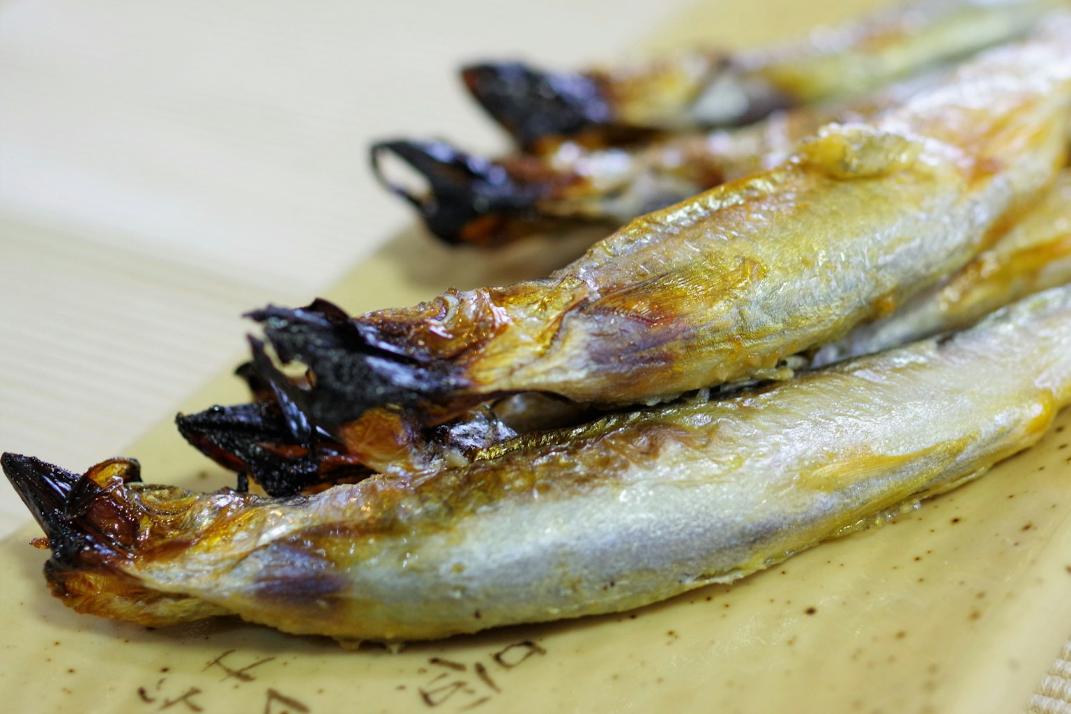 Grilled fish arranged on a plate with a golden color