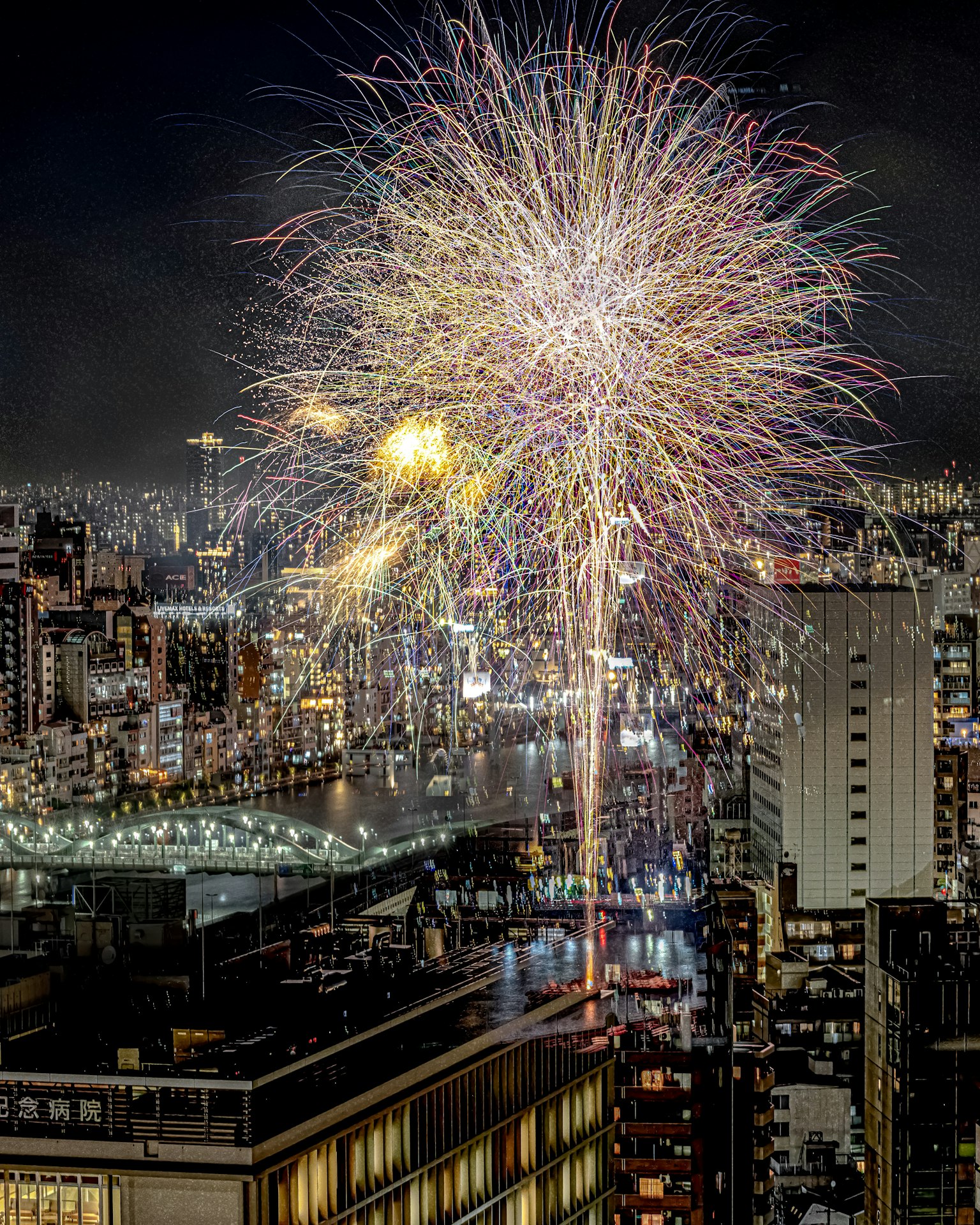 Des feux d'artifice explosent dans le ciel nocturne au-dessus d'une ville animée
