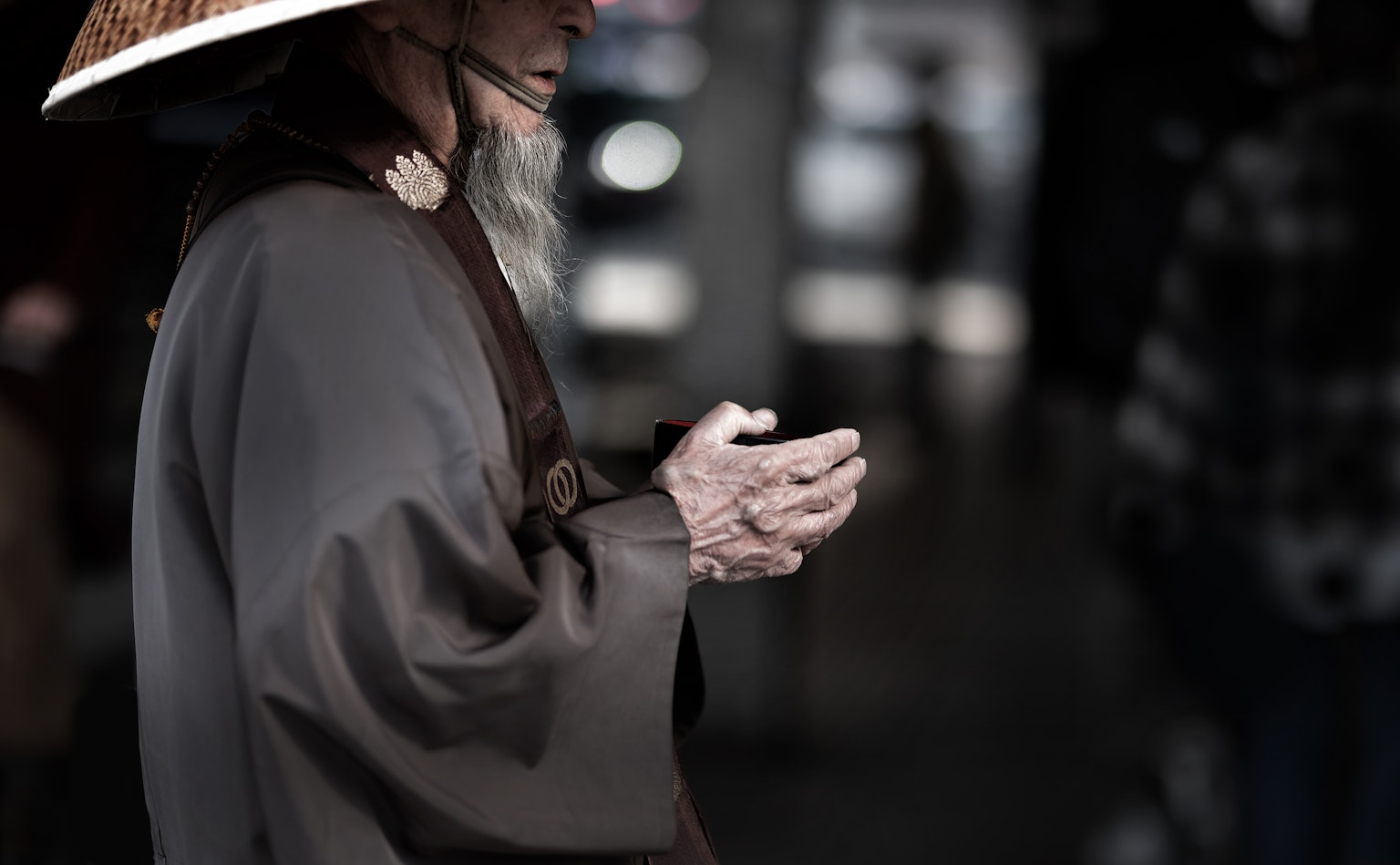 一位戴着帽子的老人双手合十