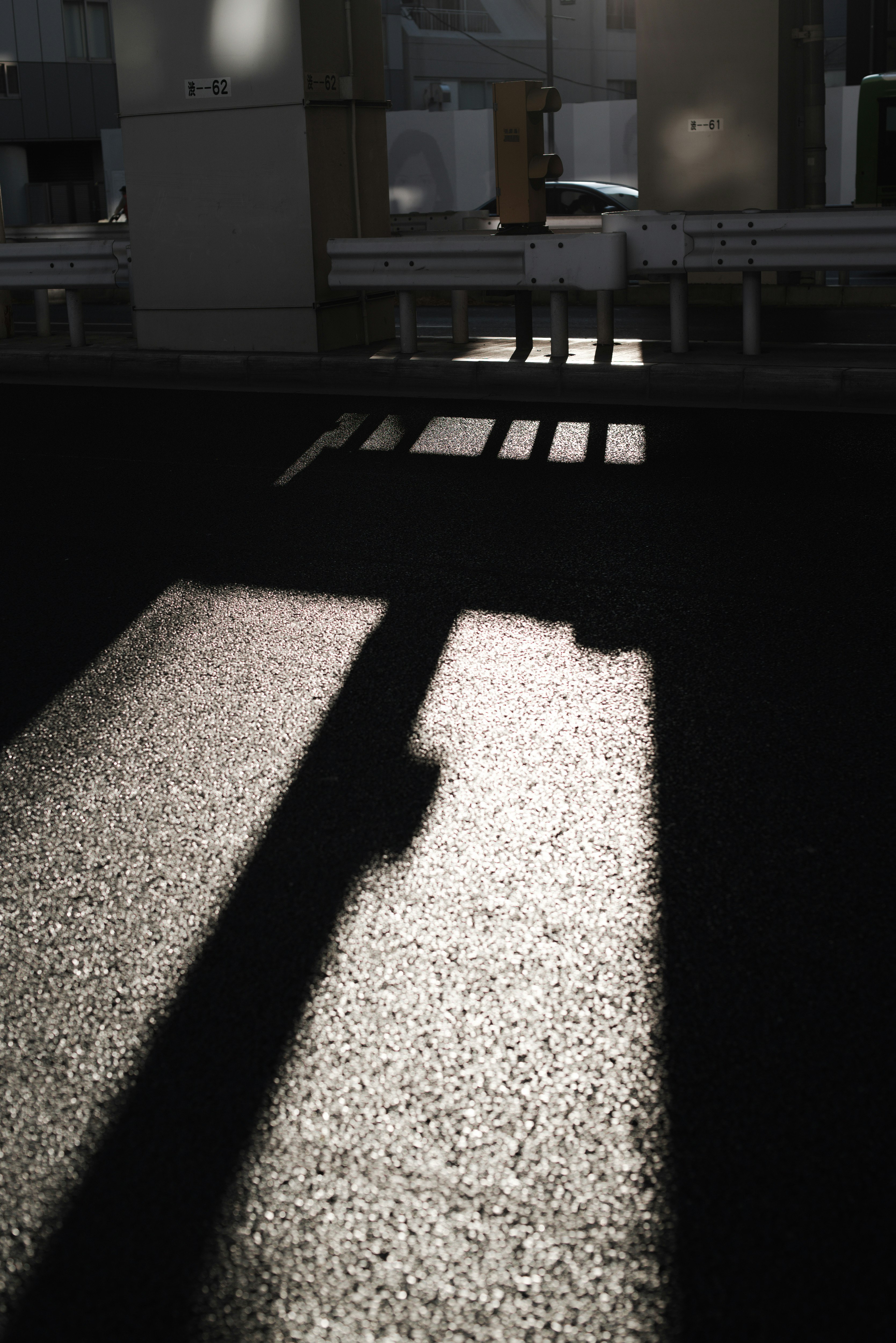 伸びる影が交差する六本木通りの街角