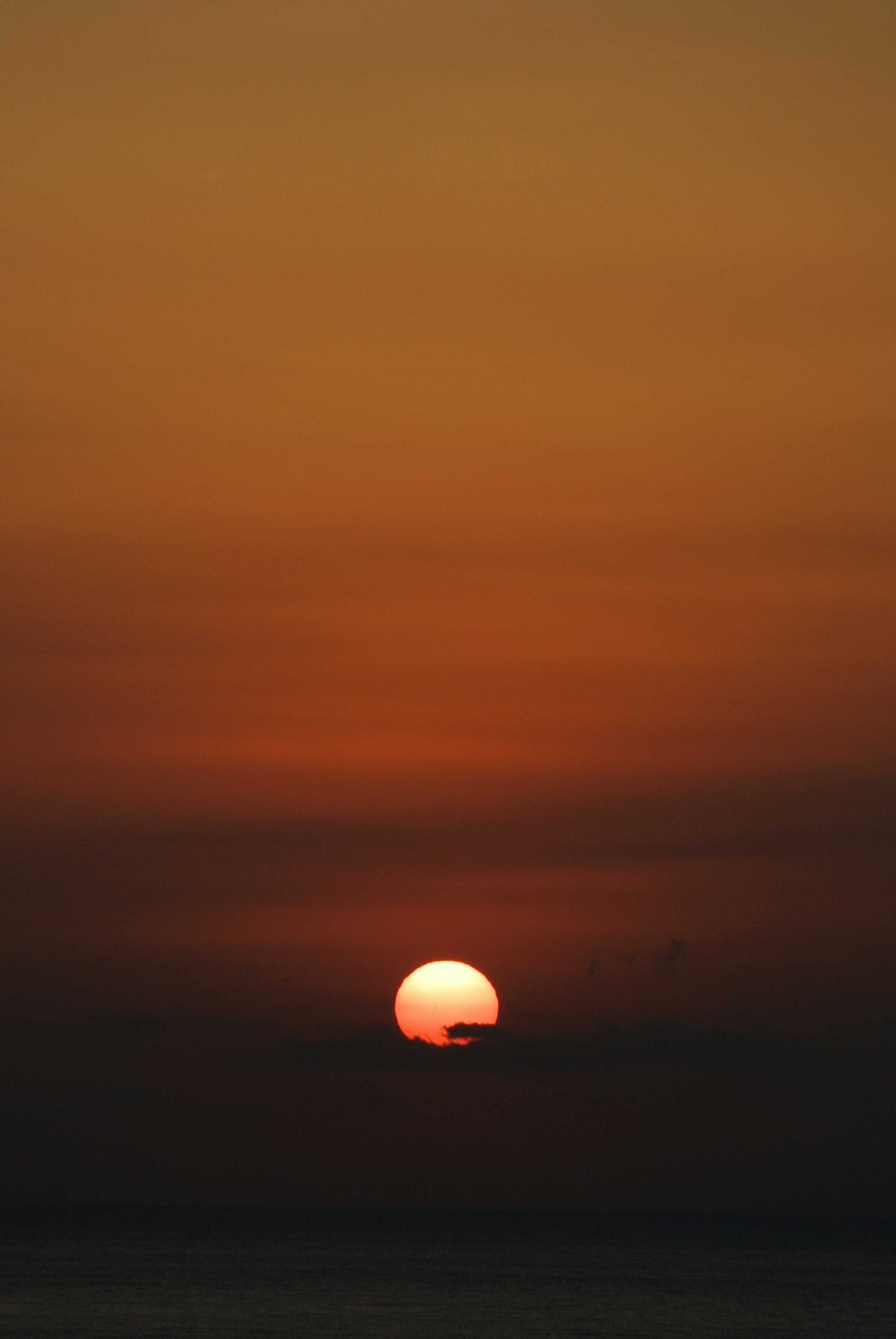 夕焼けの水平線に浮かぶ太陽