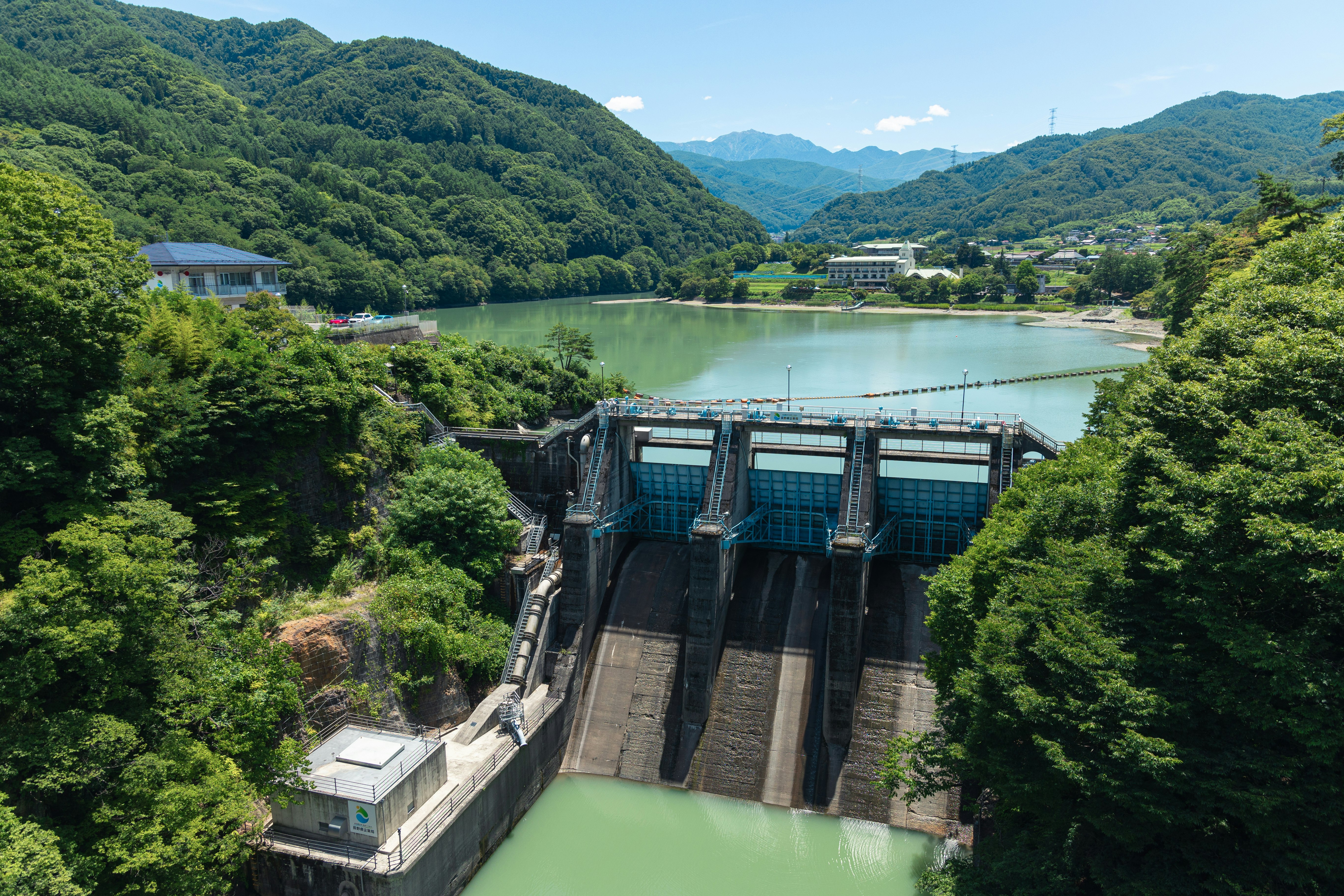 vue d’un barrage et d’un réservoir entourés de montagnes verdoyantes