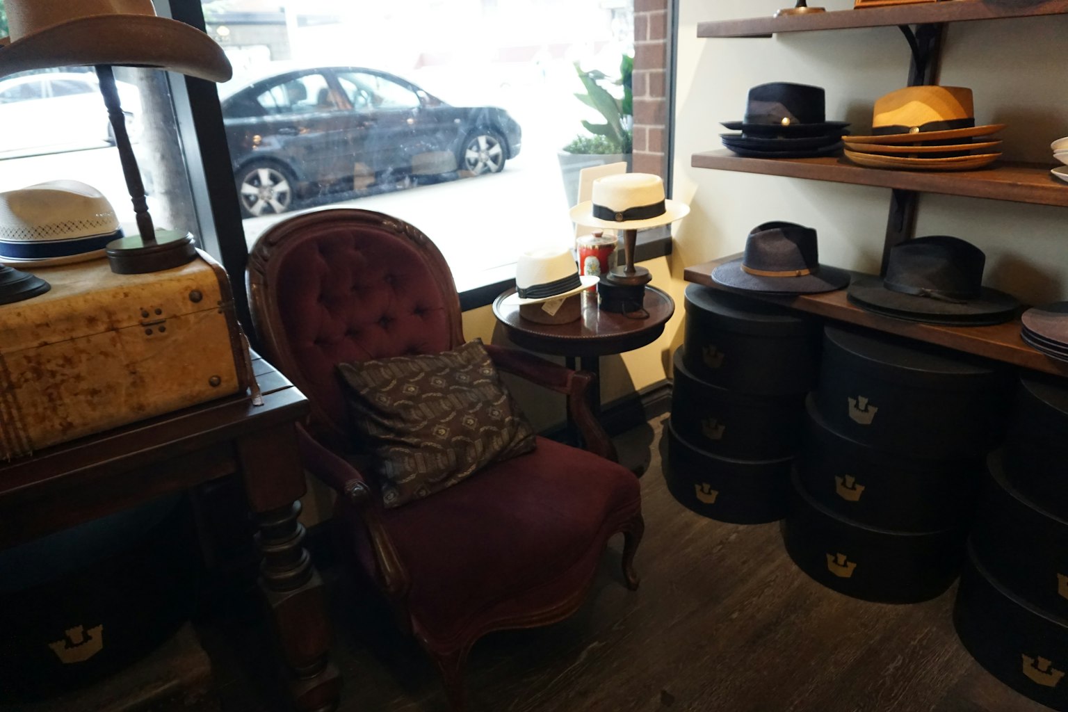 Interno di un negozio di cappelli con una sedia rossa e scaffali di cappelli