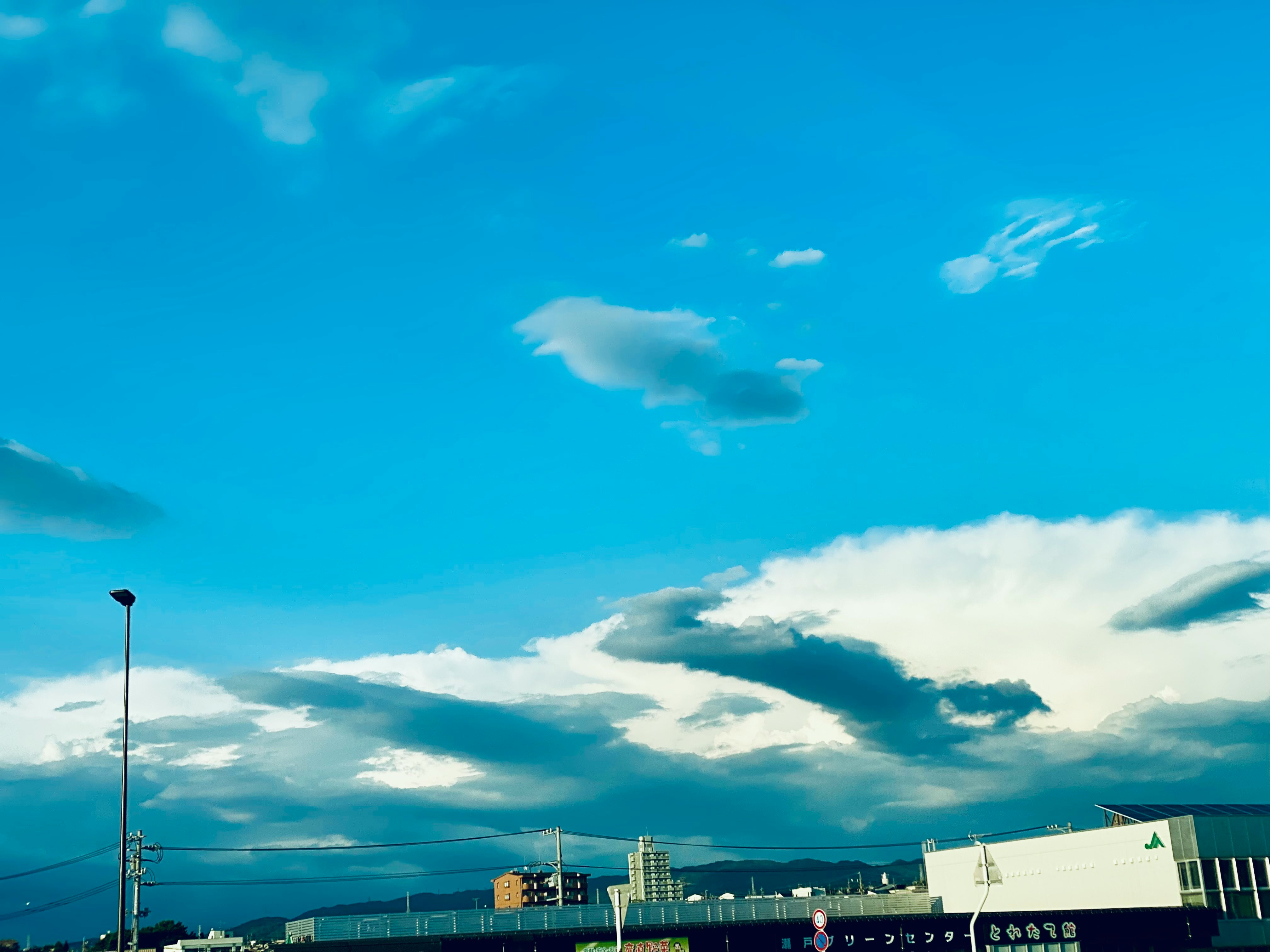 青空に広がる雲と遠景の街並み