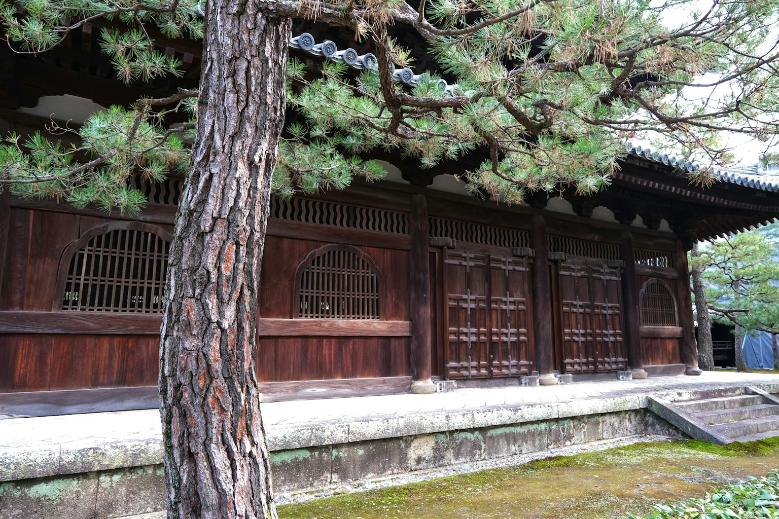 Vue latérale d'un bâtiment japonais traditionnel avec des murs en bois et des fenêtres à treillis