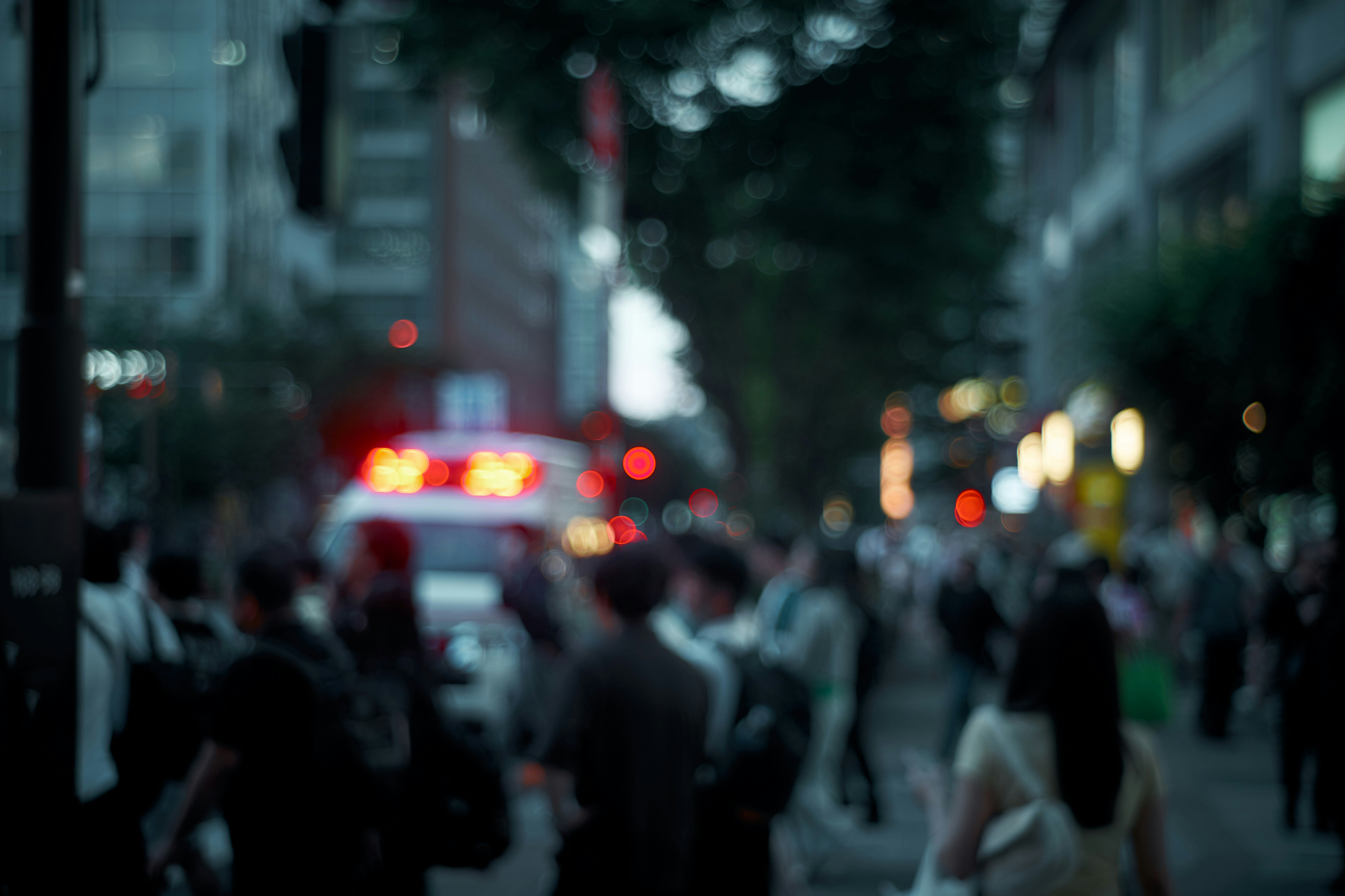 にぎやかな街の通りを人々が歩く夜のスナップ