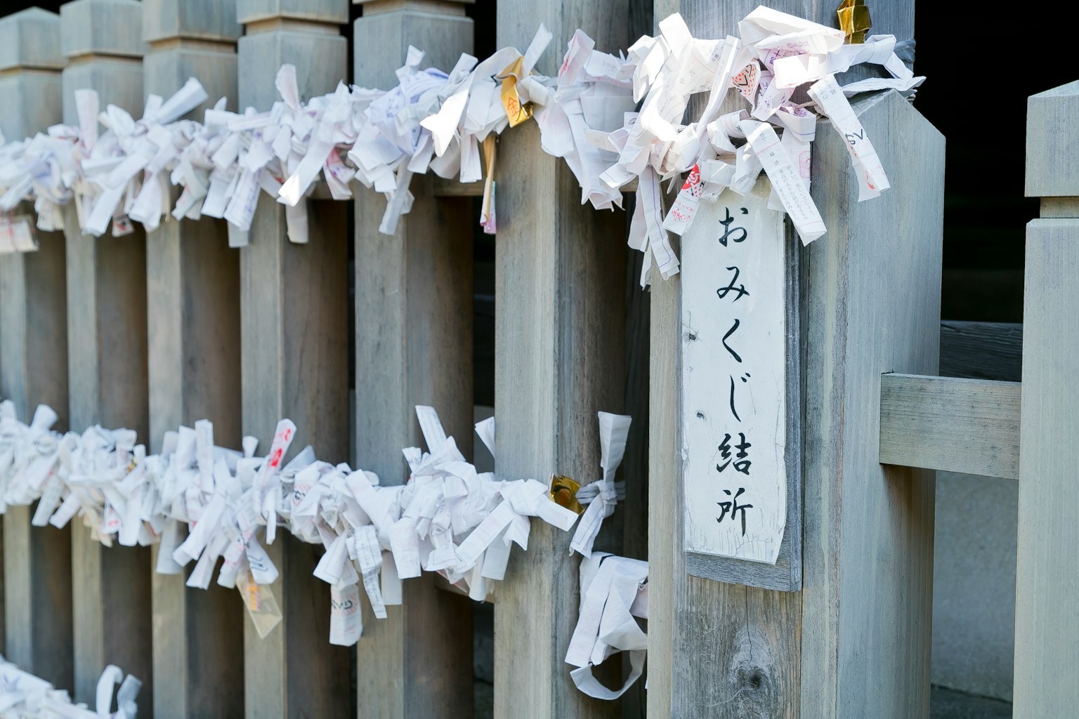 Tiras de fortuna atadas en un santuario omikuji blancos colgando de postes de madera
