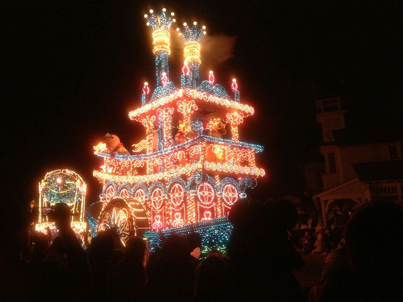 Float parade berwarna-warni yang diterangi di malam hari selama festival
