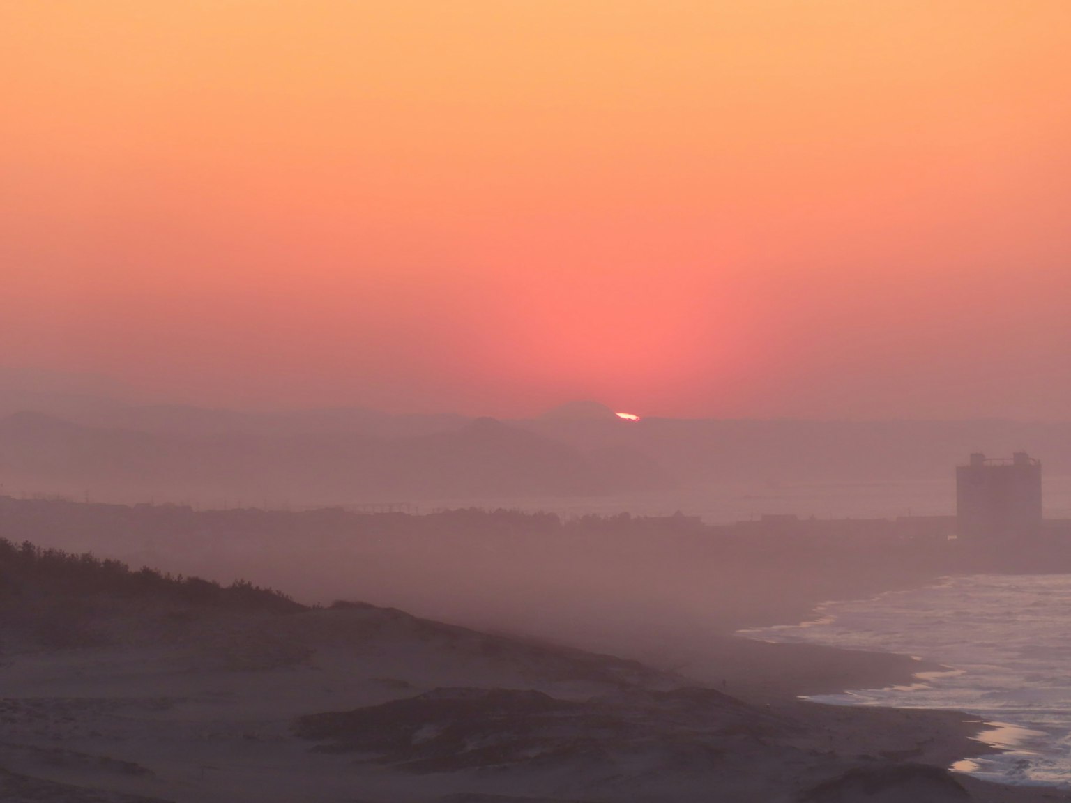 Paysage côtier au coucher de soleil avec des dégradés doux d'orange et de violet