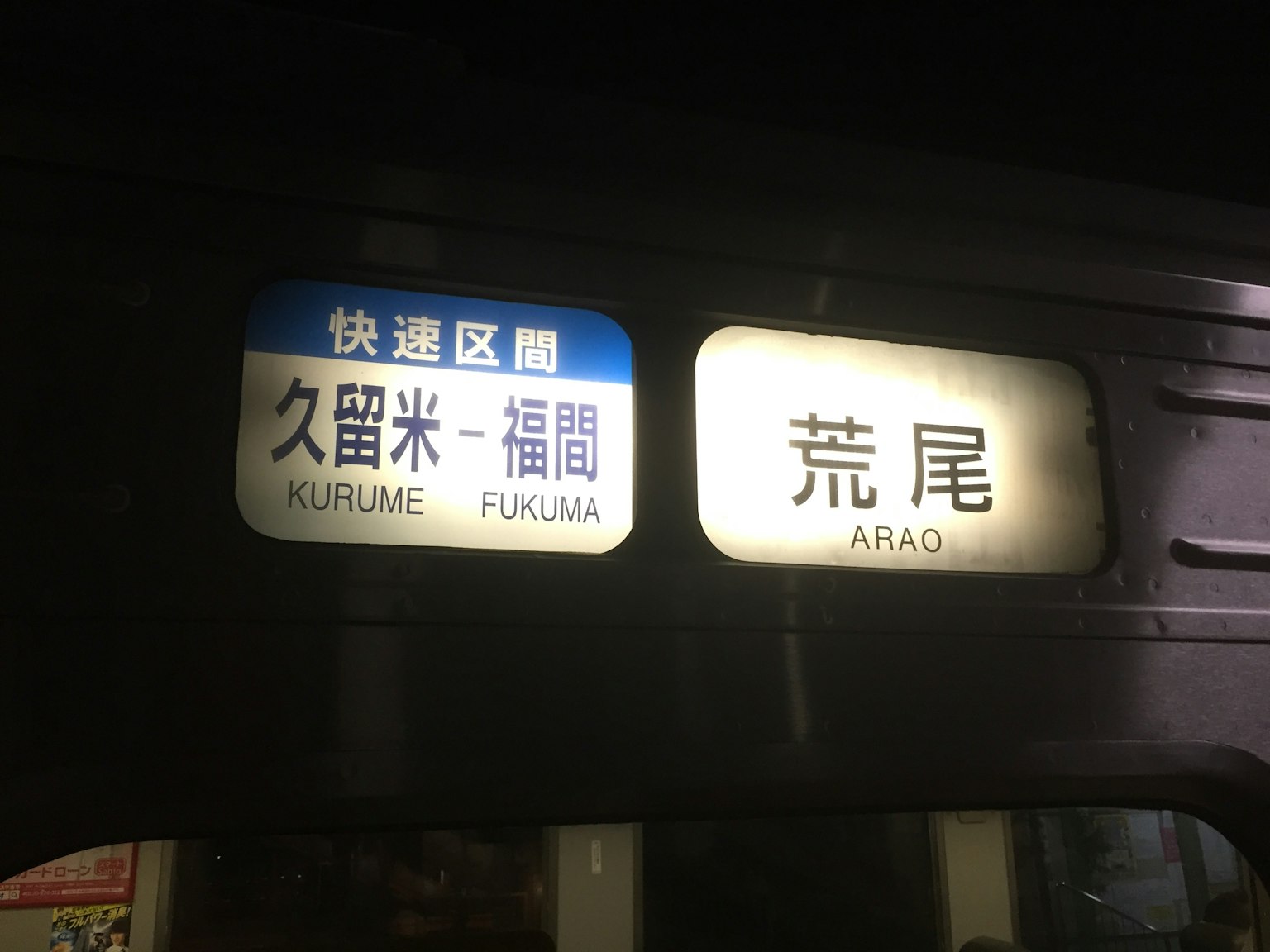 夜间火车站标志显示久留米福间和荒尾