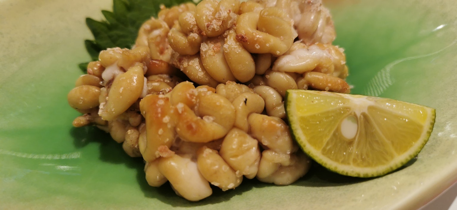 Mariscos frescos servidos al estilo sashimi con una rodaja de lima