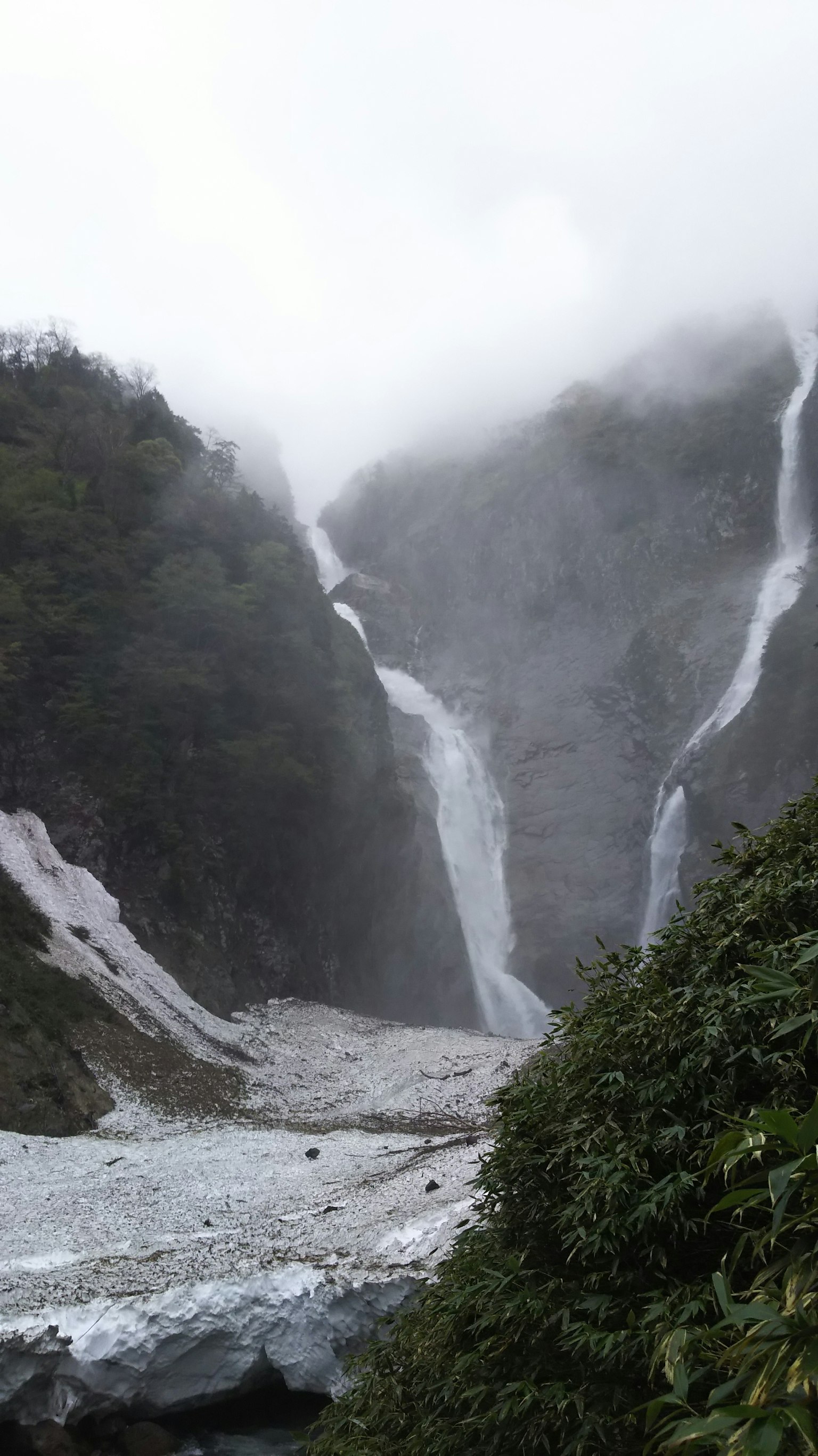 霧氣繚繞的山脈中的瀑布與冰川