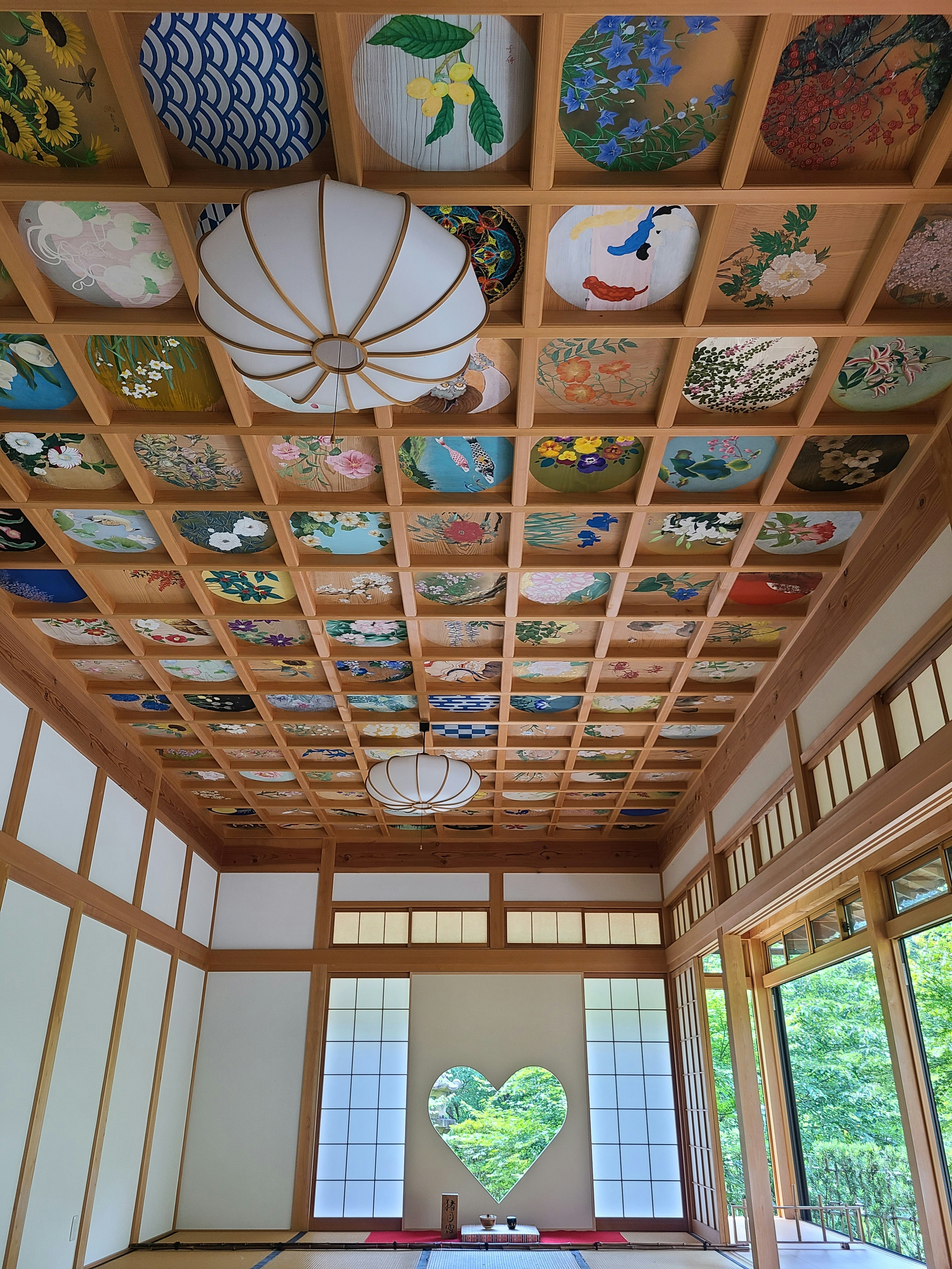 木の格子天井に飾られた絵柄タイルのある和風の室内空間