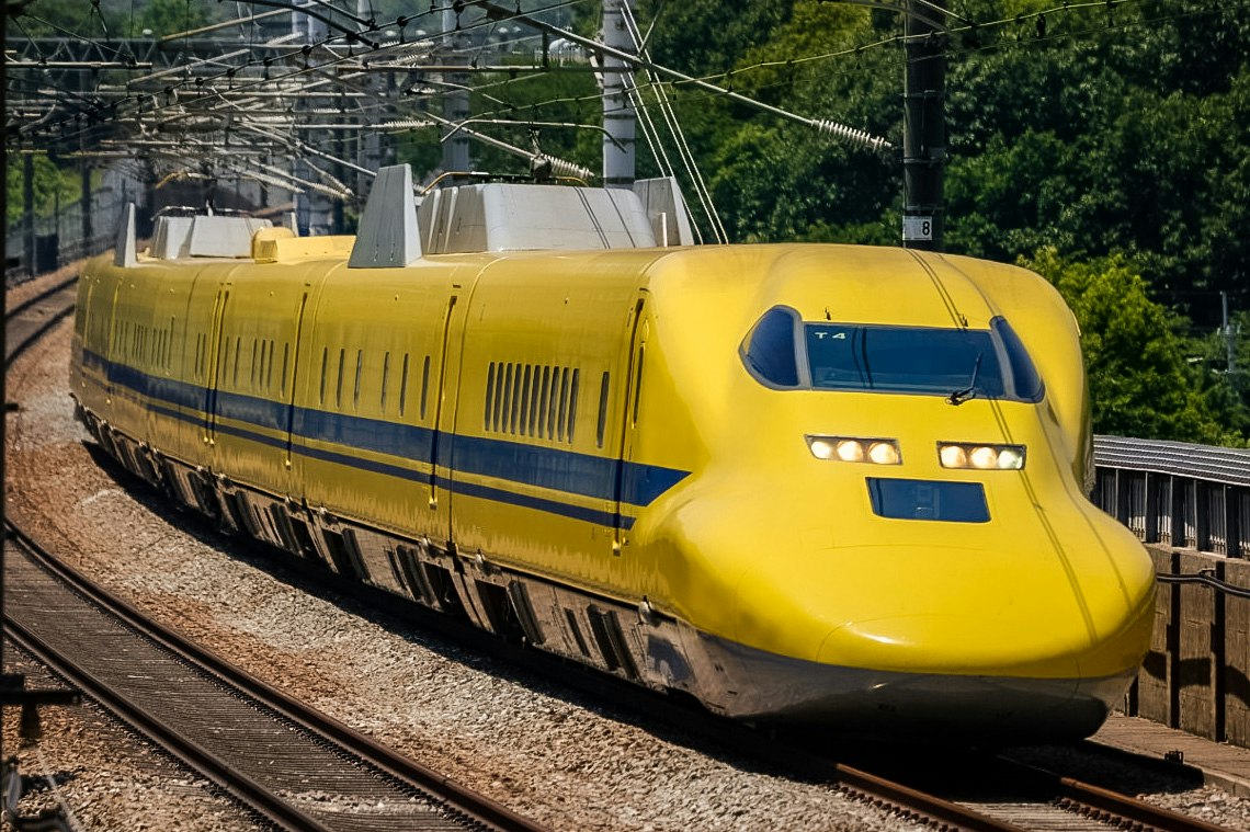 vista frontal de un tren de alta velocidad amarillo sobre las vías