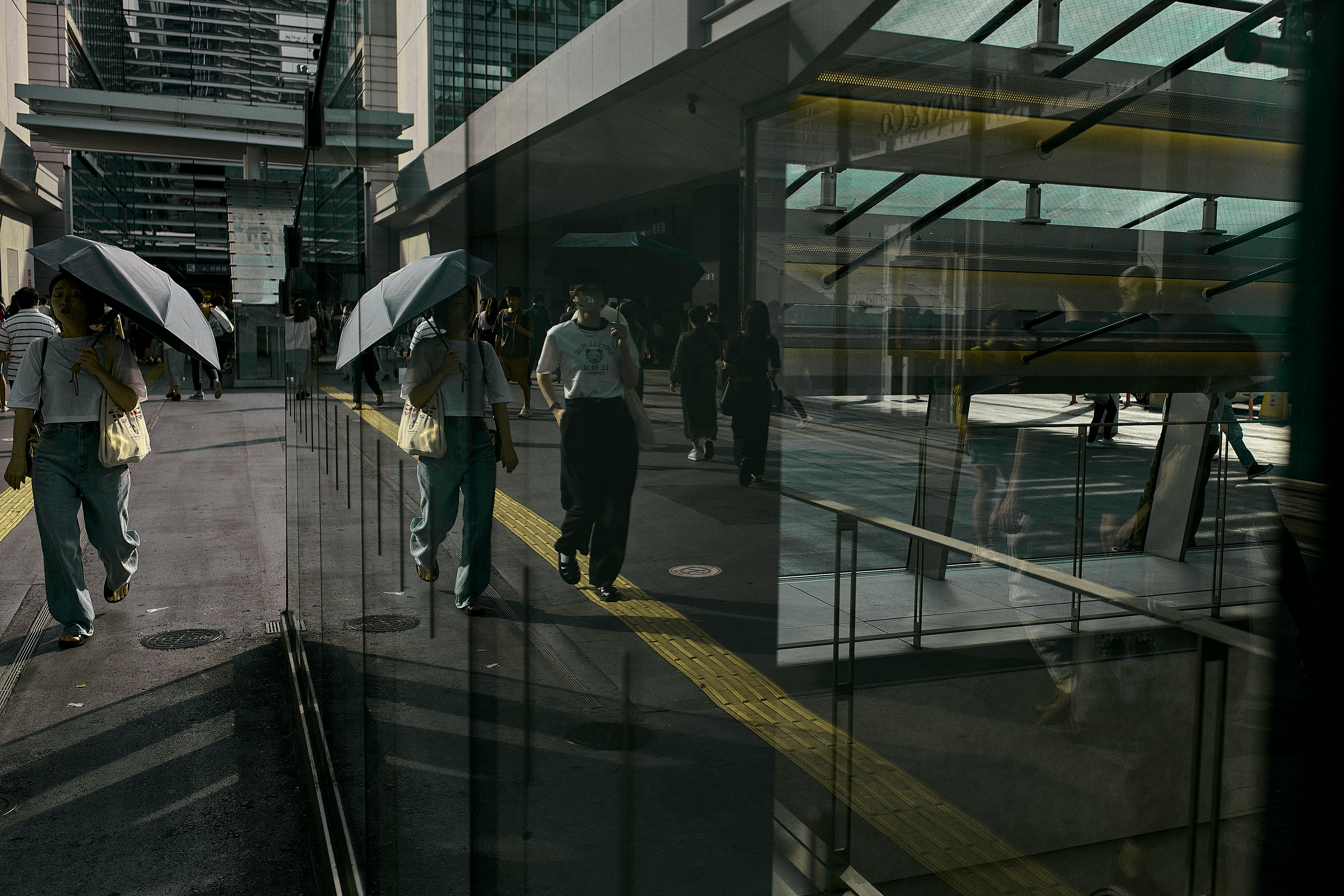 Escena de estación moderna con personas caminando con paraguas