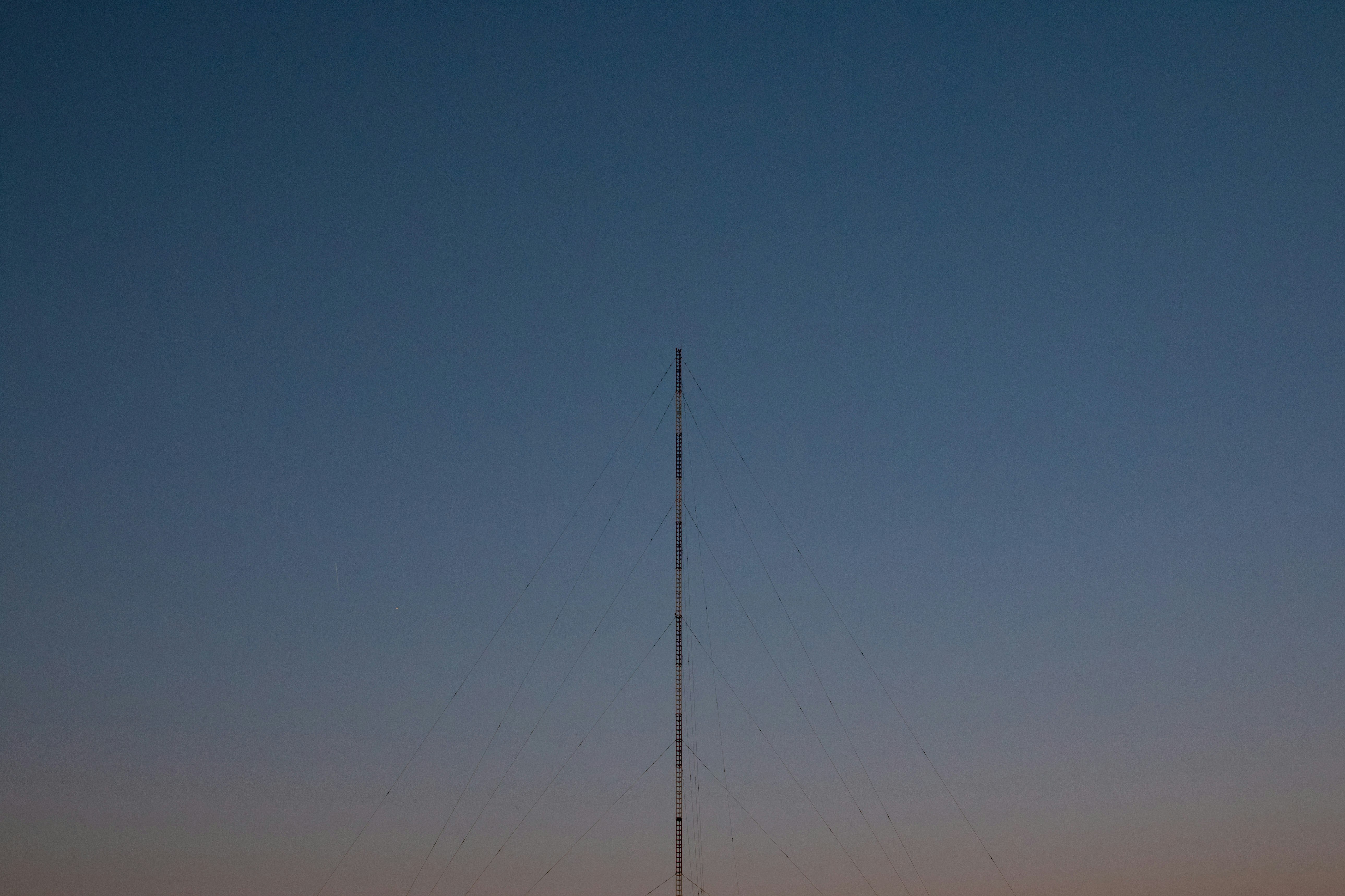 夕暮れの空に伸びる細い電波塔