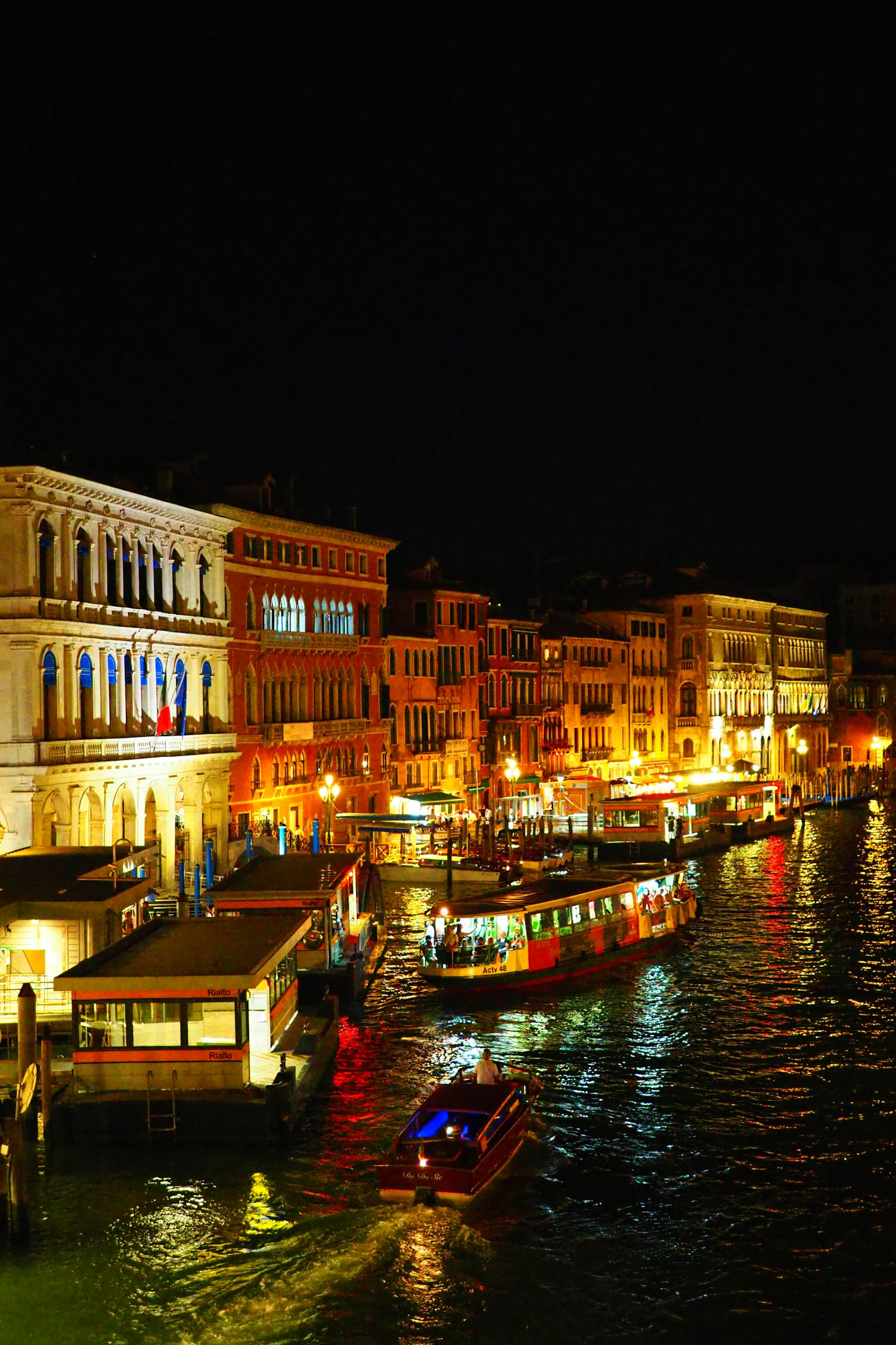 Canal de Venecia de noche con edificios iluminados y barcos