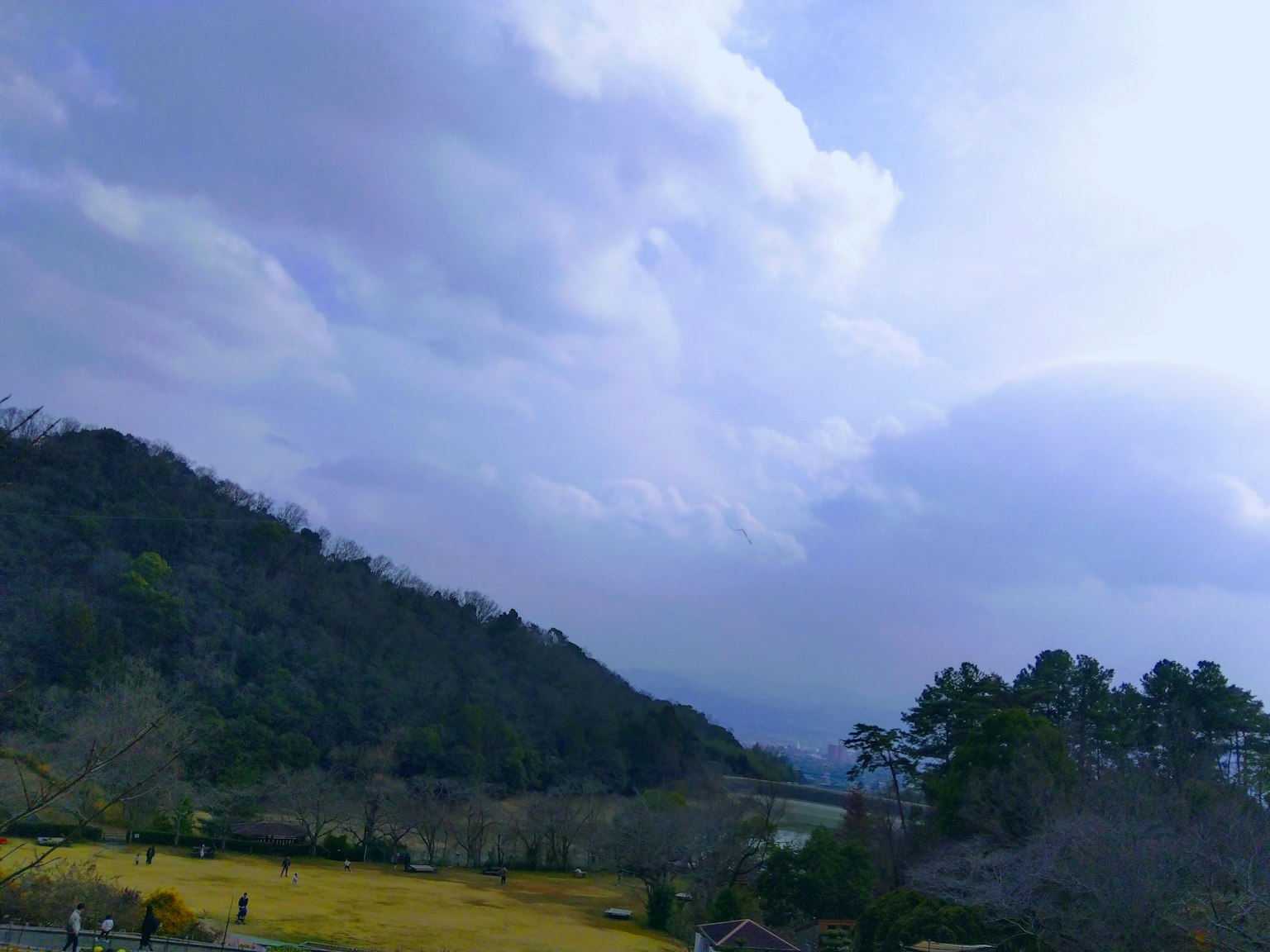 Montañas y campos bajo un cielo azul con nubes