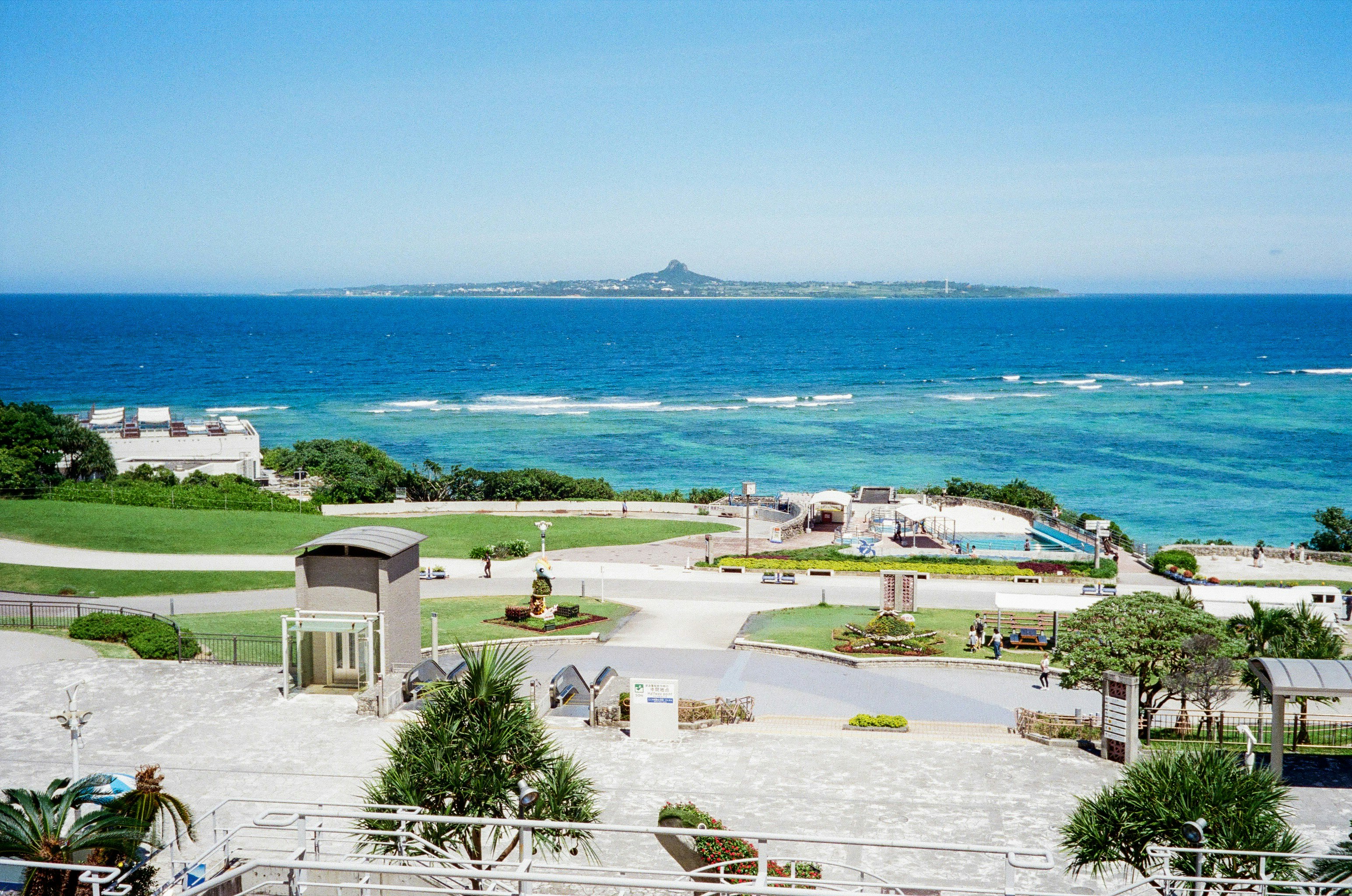 Rasenfläche und Promenade eines Parks mit Blick auf den Ozean