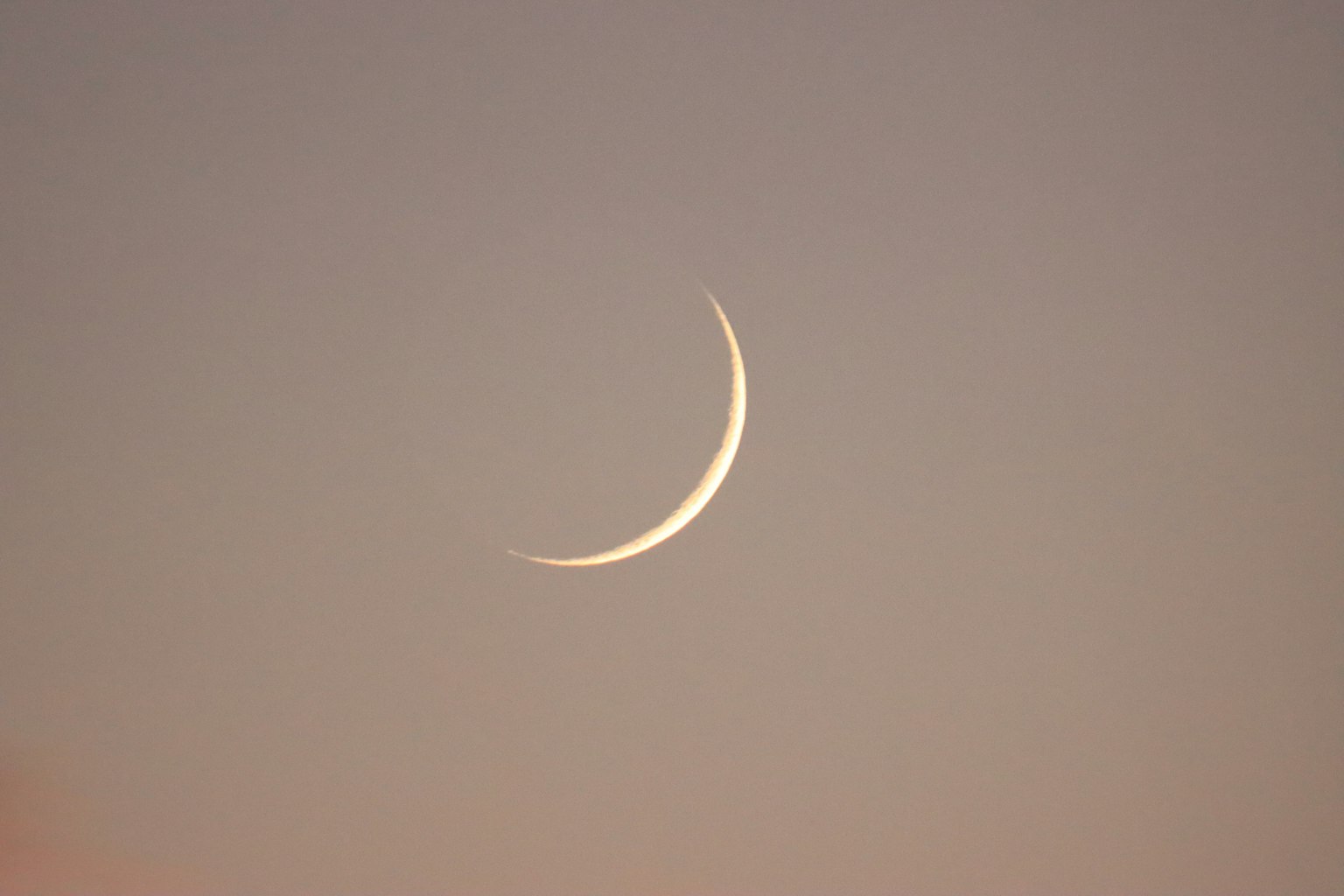 Thin crescent moon in twilight sky
