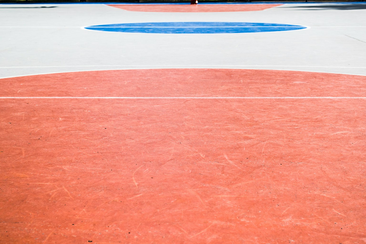 Área circular roja con un círculo azul en una cancha deportiva