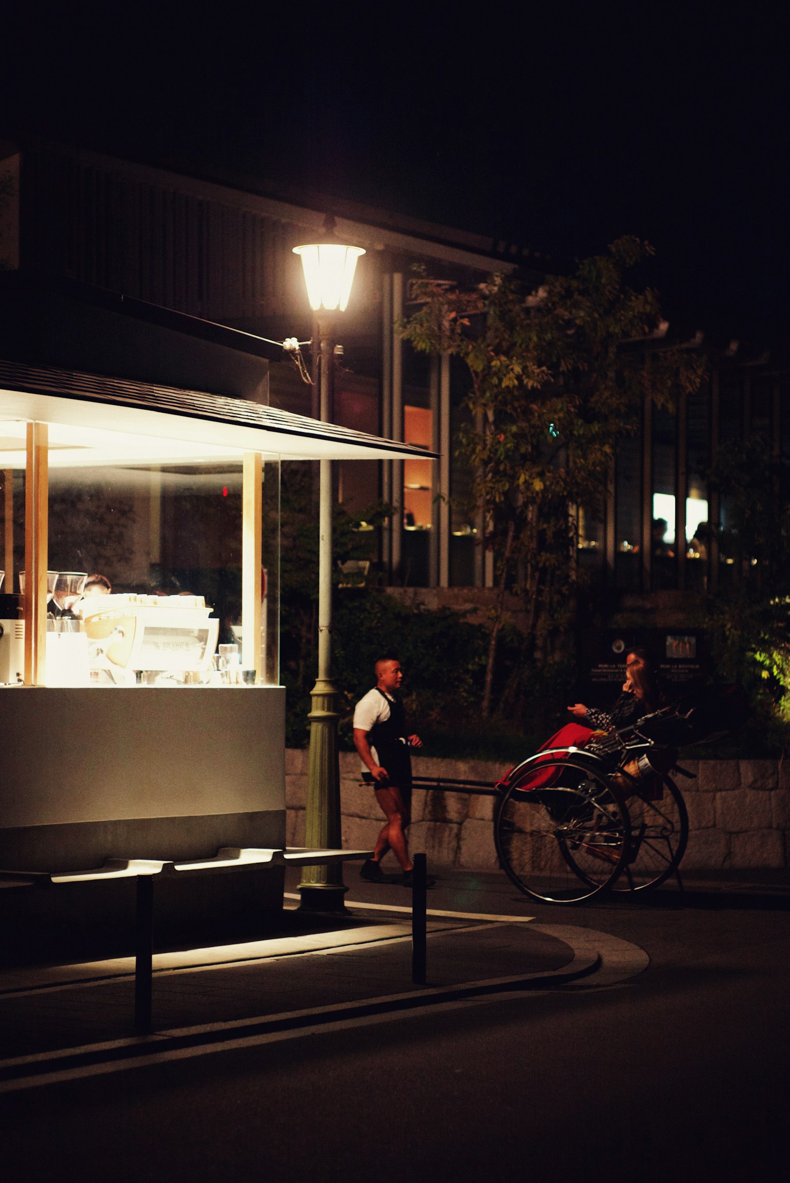 Nighttime scene with a cafe and a rickshaw