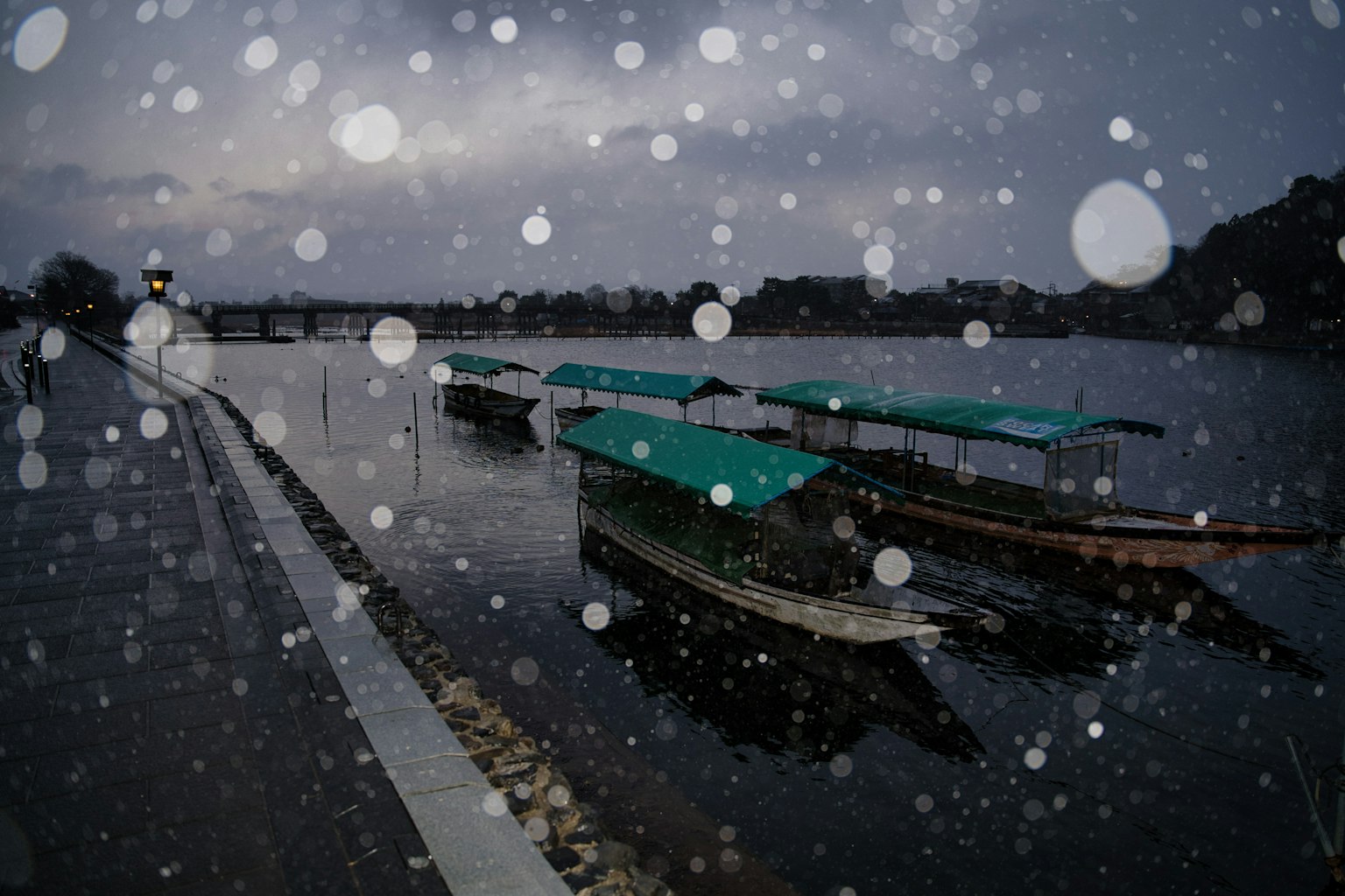 Scena di fiume con barche e neve che cade