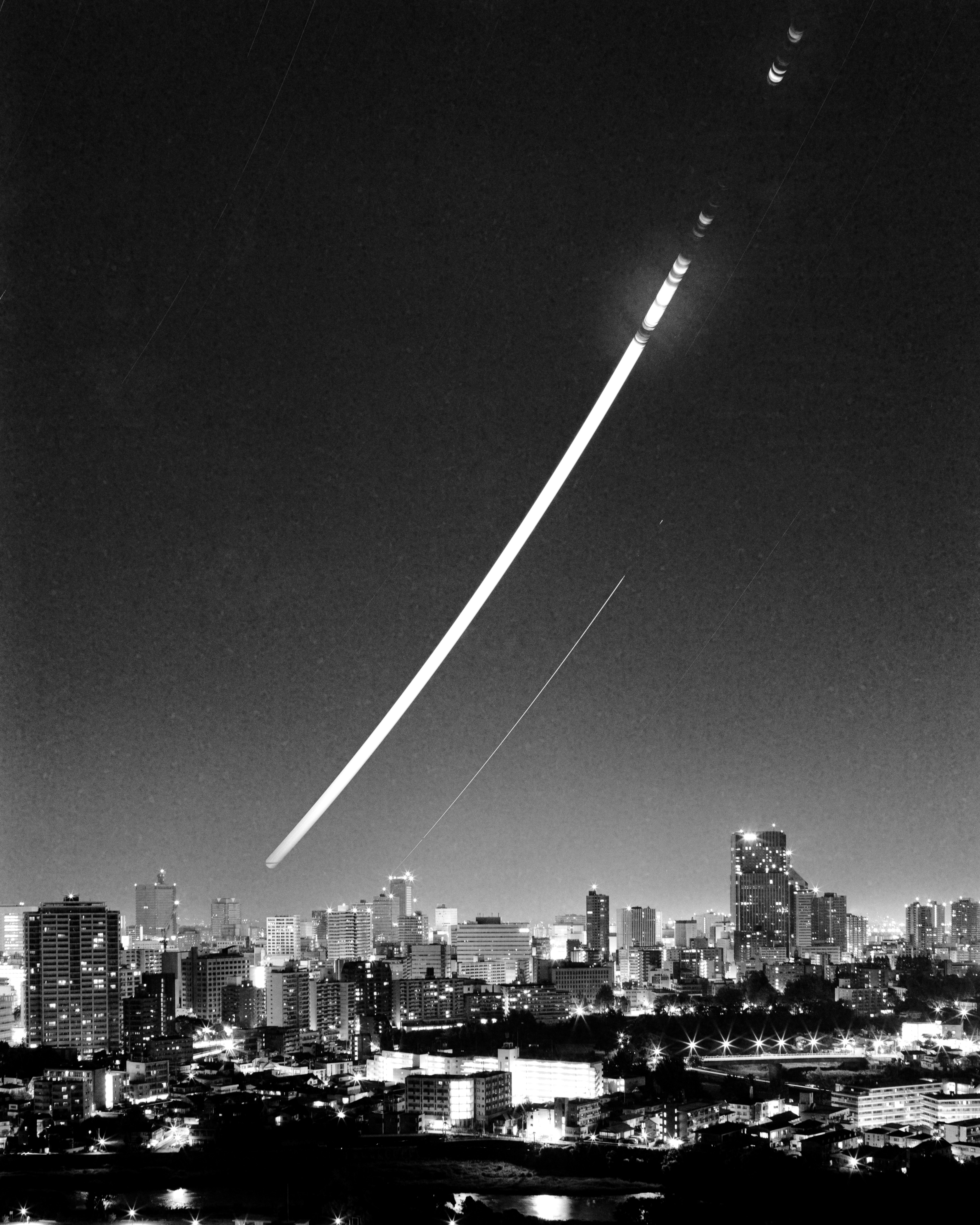 夜空中弧形光軌與城市天際線